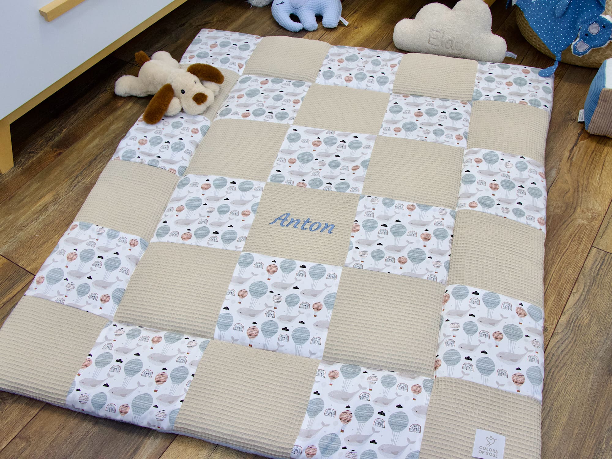Detail der handgemachten Krabbeldecke aus Waffelpique Beige und Baumwollsatin mit Colors of Soul Label
