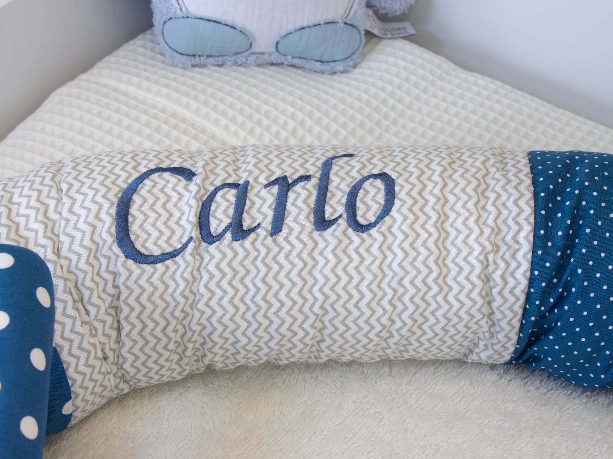 Detailansicht Stickname Carlo auf grauem Zickzack-Stoff der Bettschnecke