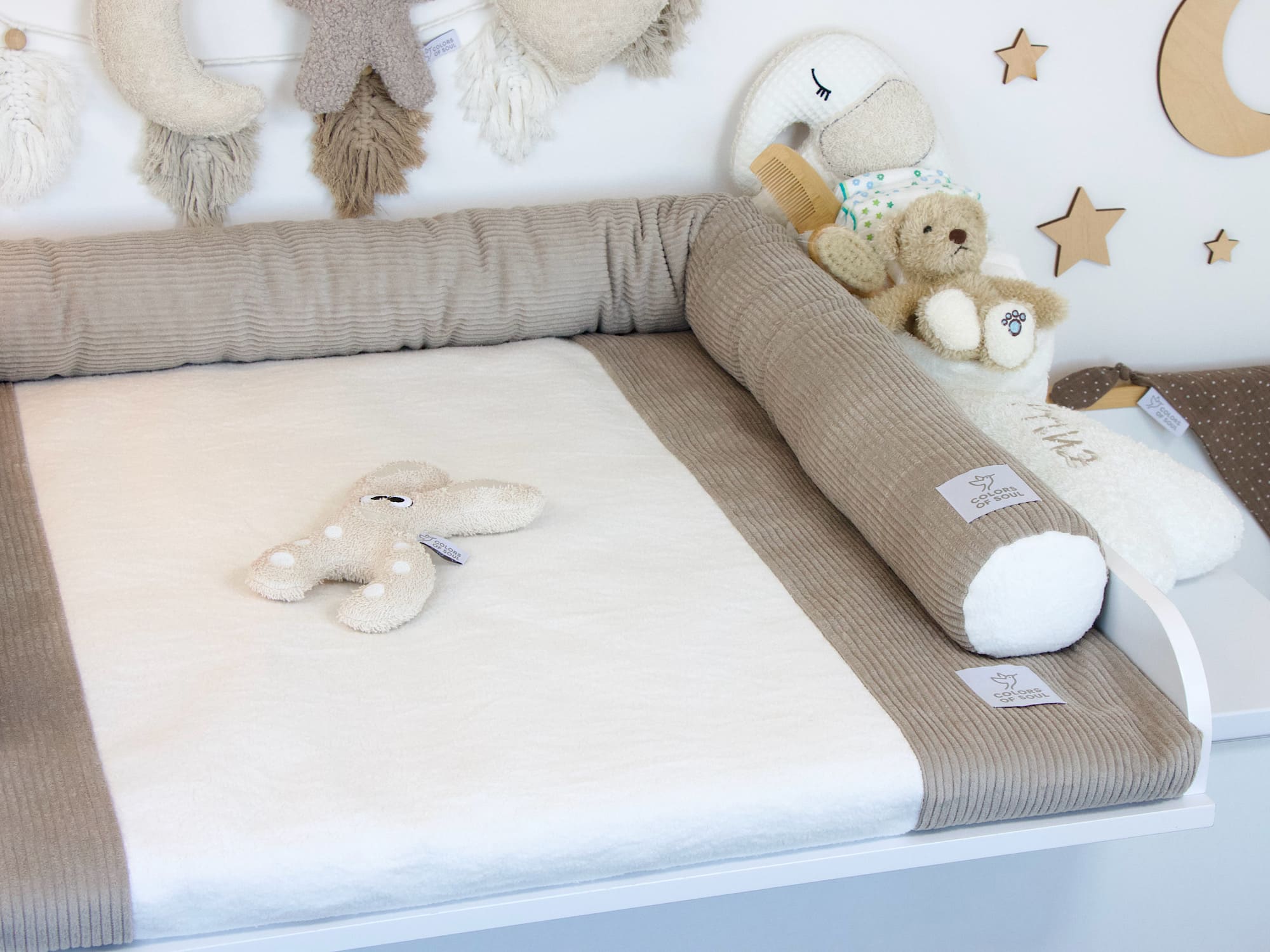 Klassische Bettschlange aus Cord Beige auf weißer Wickelkommode