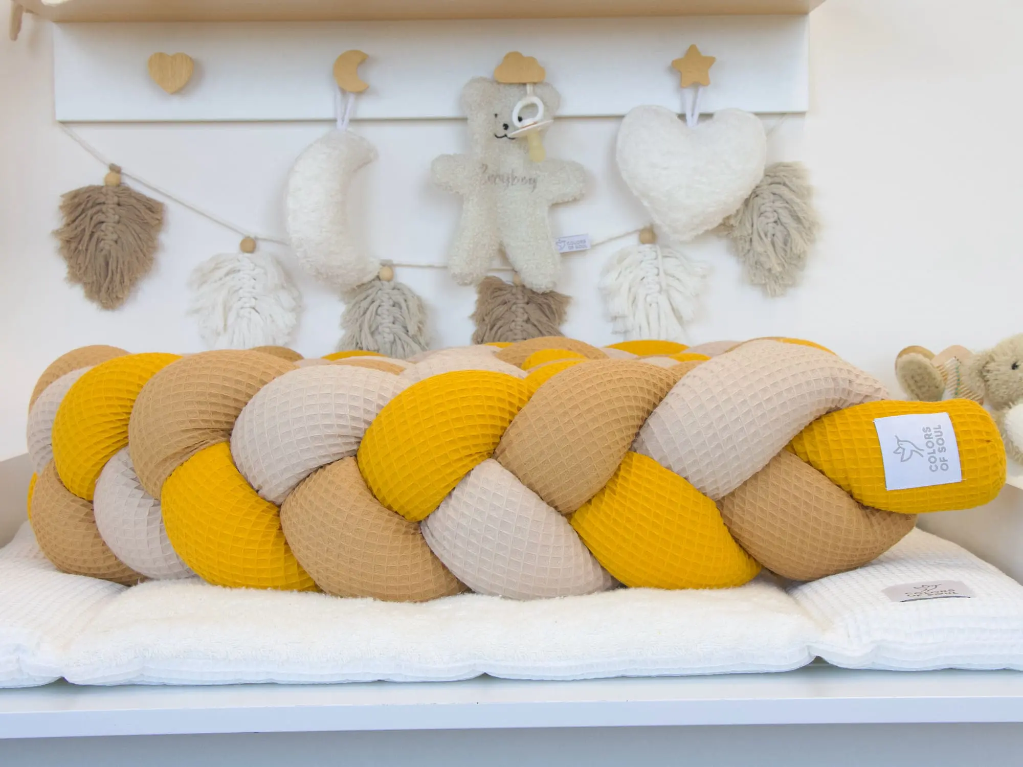 Waffelpique Bettschlange in Gelb Karamell und Beige auf Wickelauflage im Babyzimmer