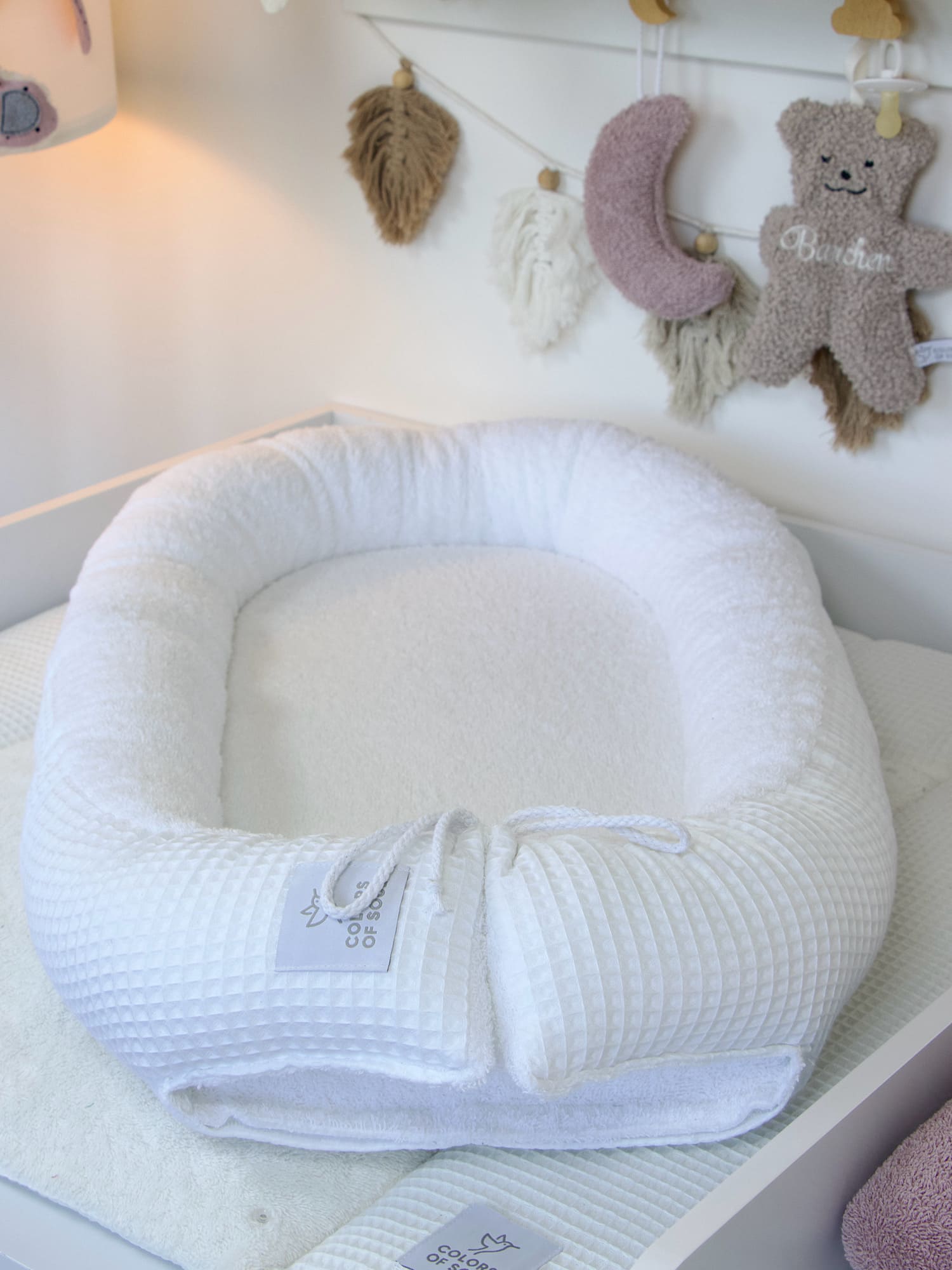 Kuscheliges Babynest in Weiß mit strukturierter Waffelpique-Umrandung und flauschiger Frottee-Liegefläche