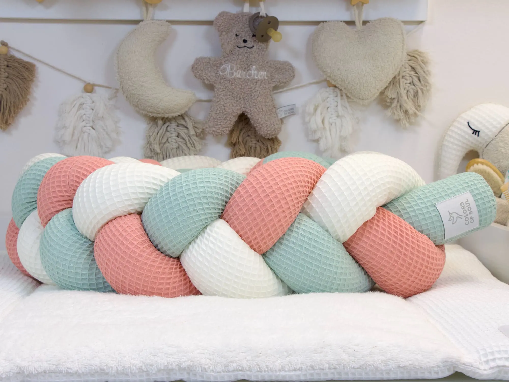 Handgemachte geflochtene Bettschlange in Creme Blush und Hellmint vor Babyzimmer Deko