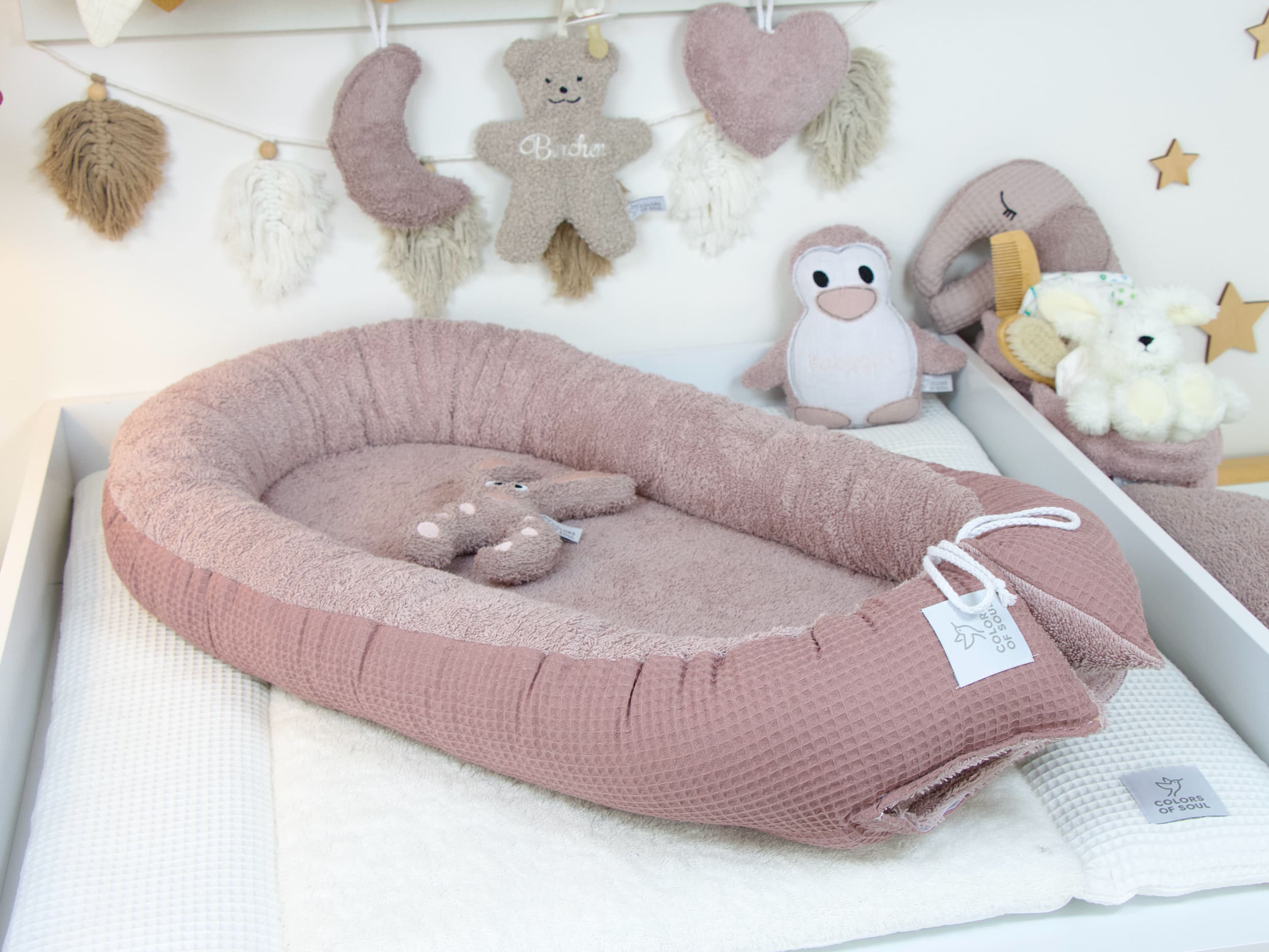 Babynest Altmalve im liebevoll dekorierten Babyzimmer – mit Holzsternen, Kuscheltieren und sanften Farben