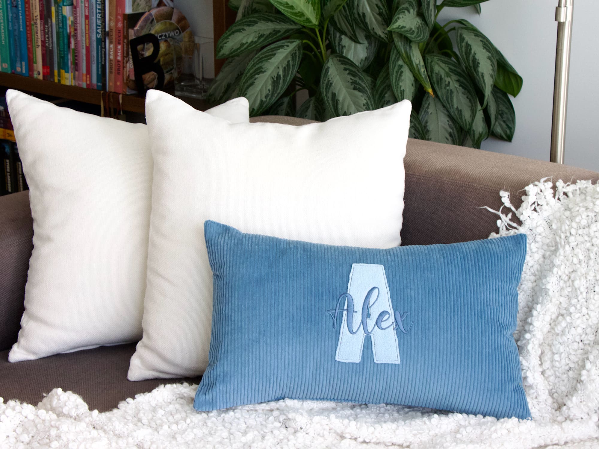 Dekokissen aus blauem Cord mit Buchstaben-Applikation Blau – Wohnbild mit Kissen und Decke
