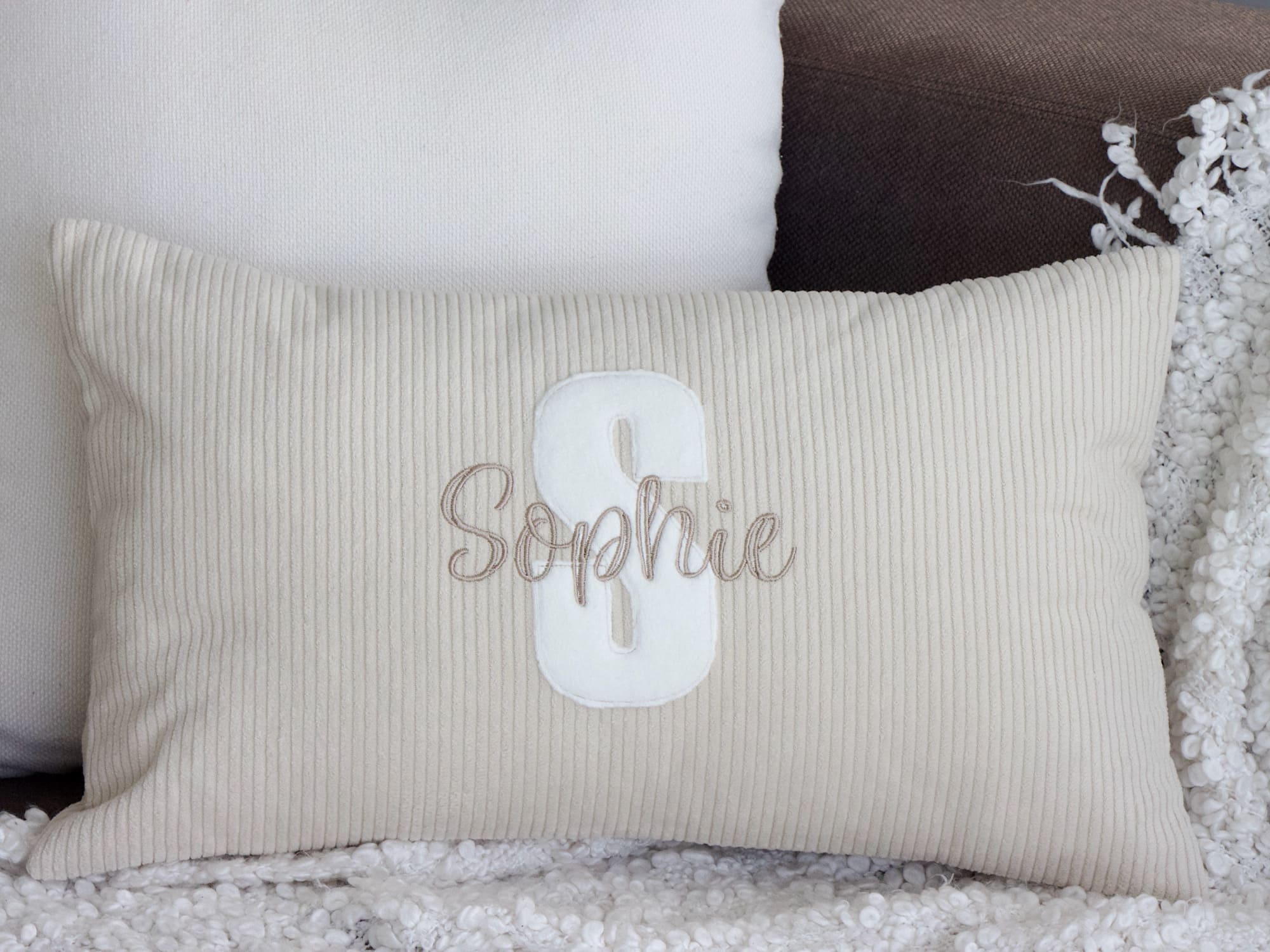 Personalisiertes Cordkissen in Light Sand mit cremefarbenem Buchstaben und Namensstickerei (Detailansicht)