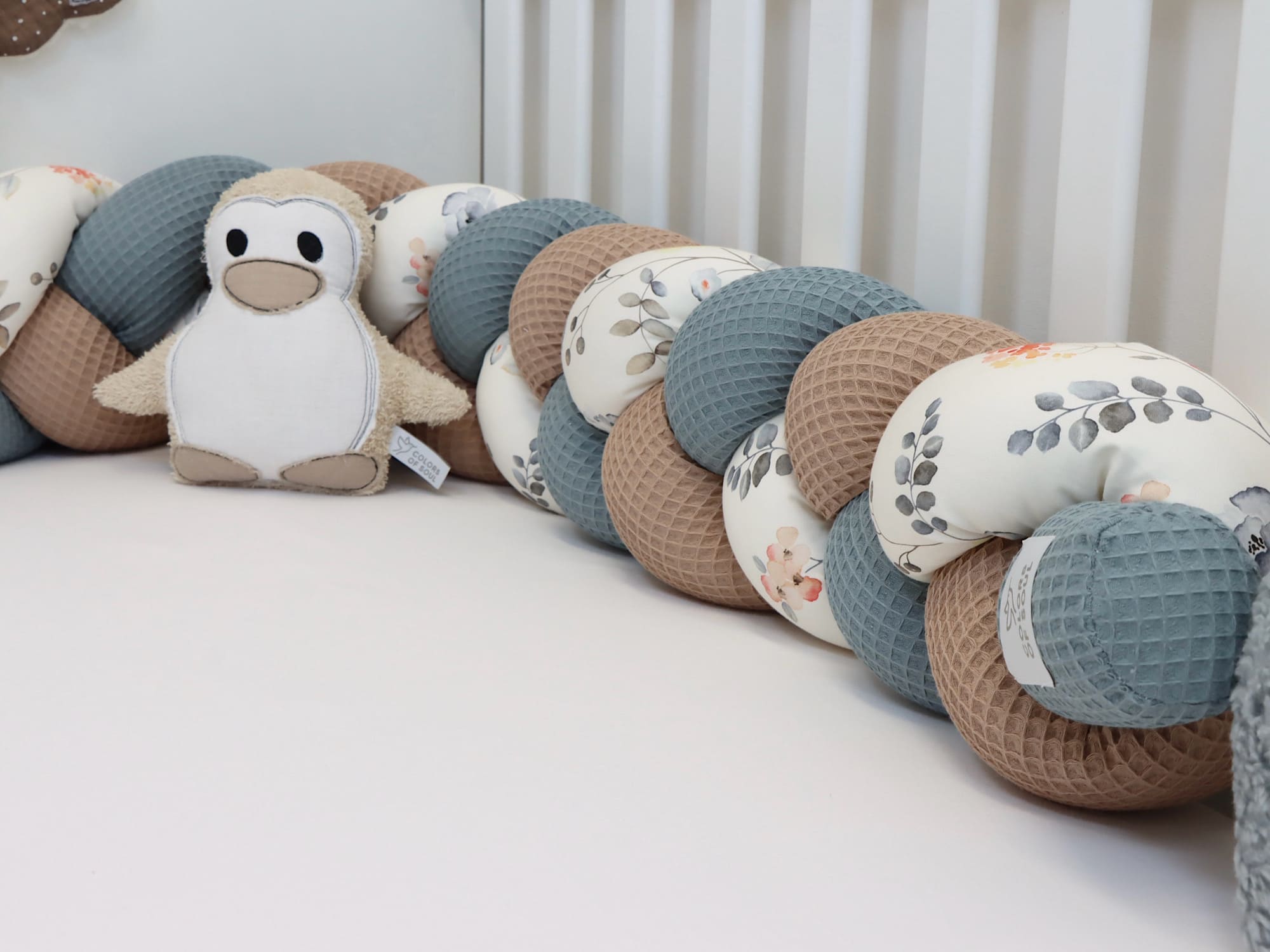 Geflochtene Bettschlange mit floralen Aquarellmotiven – sicherer Rundumschutz fürs Babybett