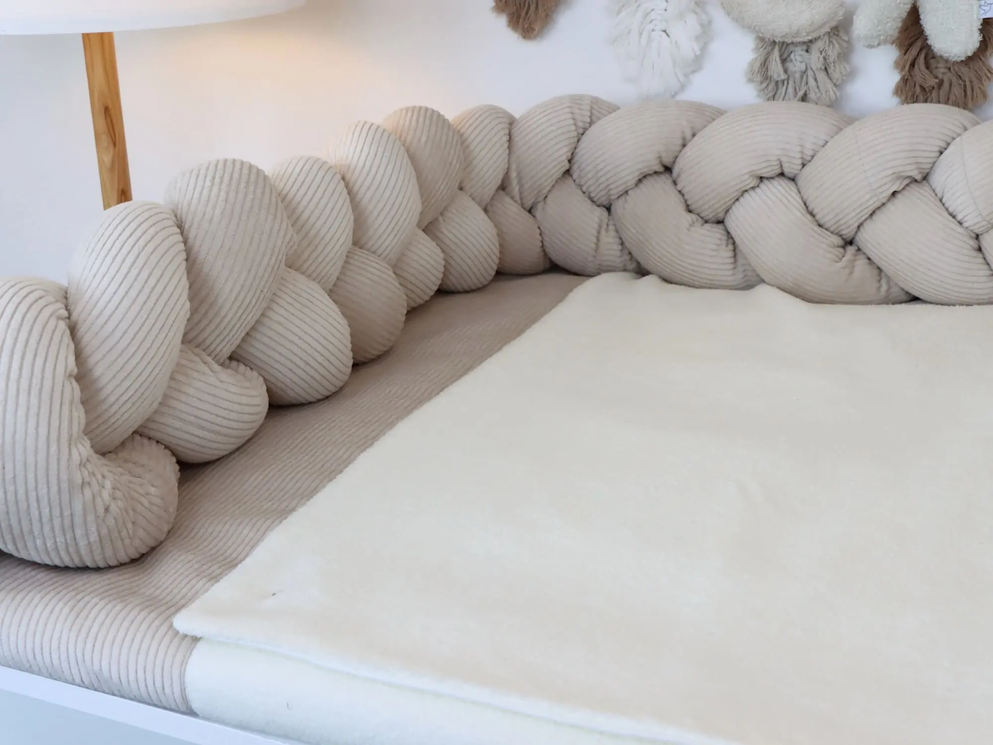 Wickelauflage mit Bezug und geflochtener Bettschlange in Cord Light Sand und Baumwollfleece Creme auf weißer Wickelkommode