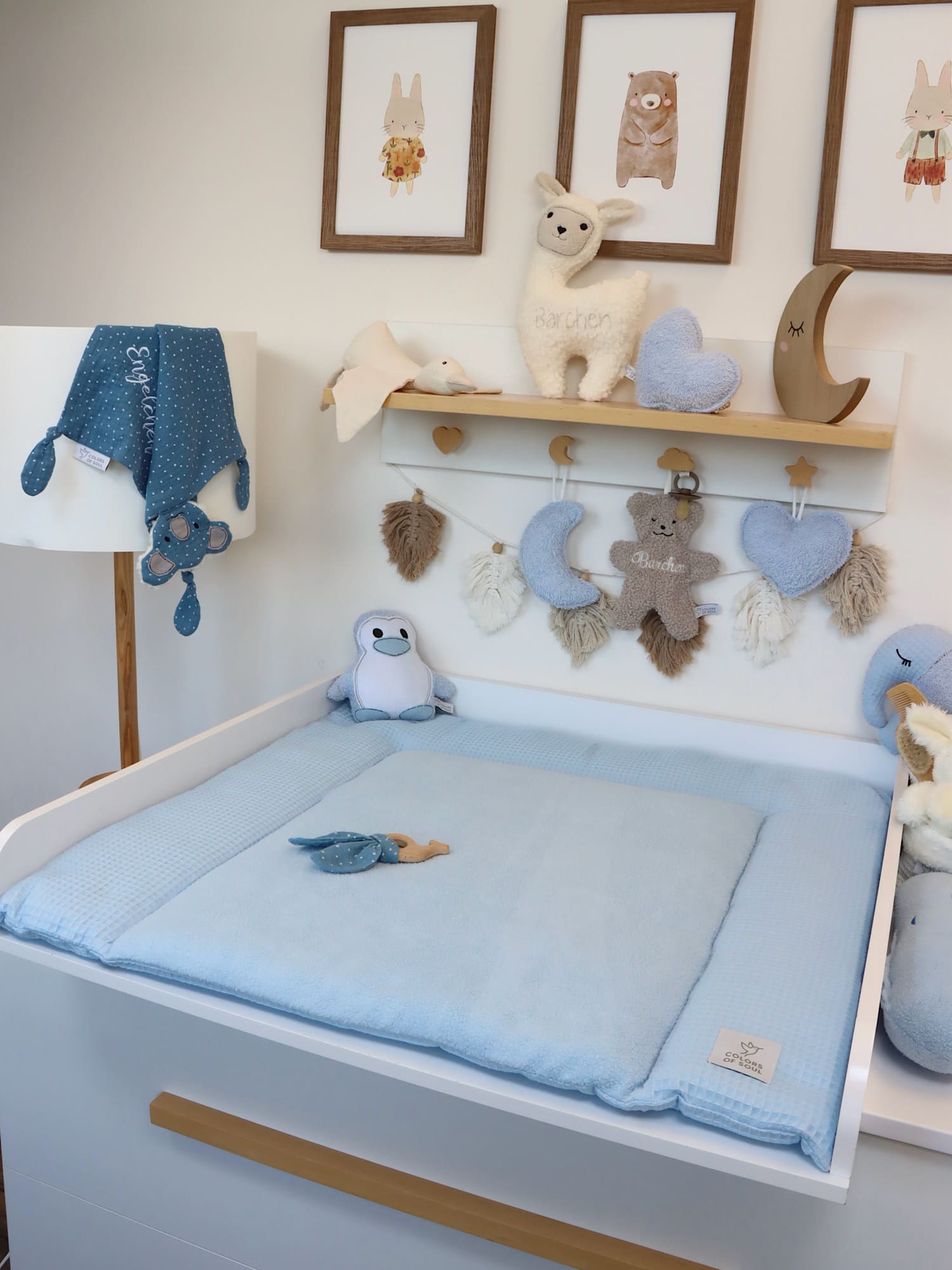 Wickelauflage hellblau mit Fleece-Liegefläche – dekoriertes Babyzimmer mit Wandbildern und Stoffspielzeug