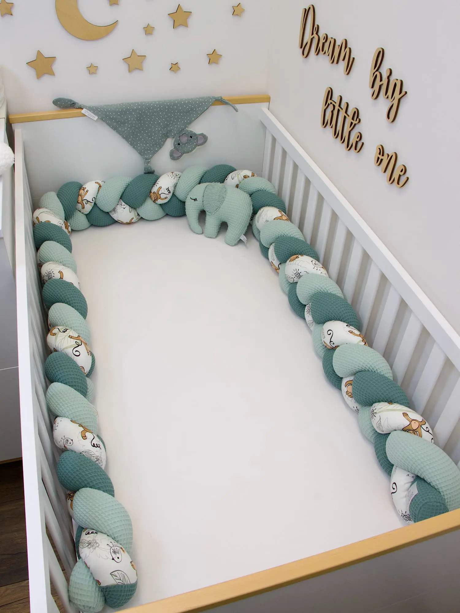 Geflochtene Nestchenschlange mit niedlichen Affen und grünem Waffelpique im Babybett