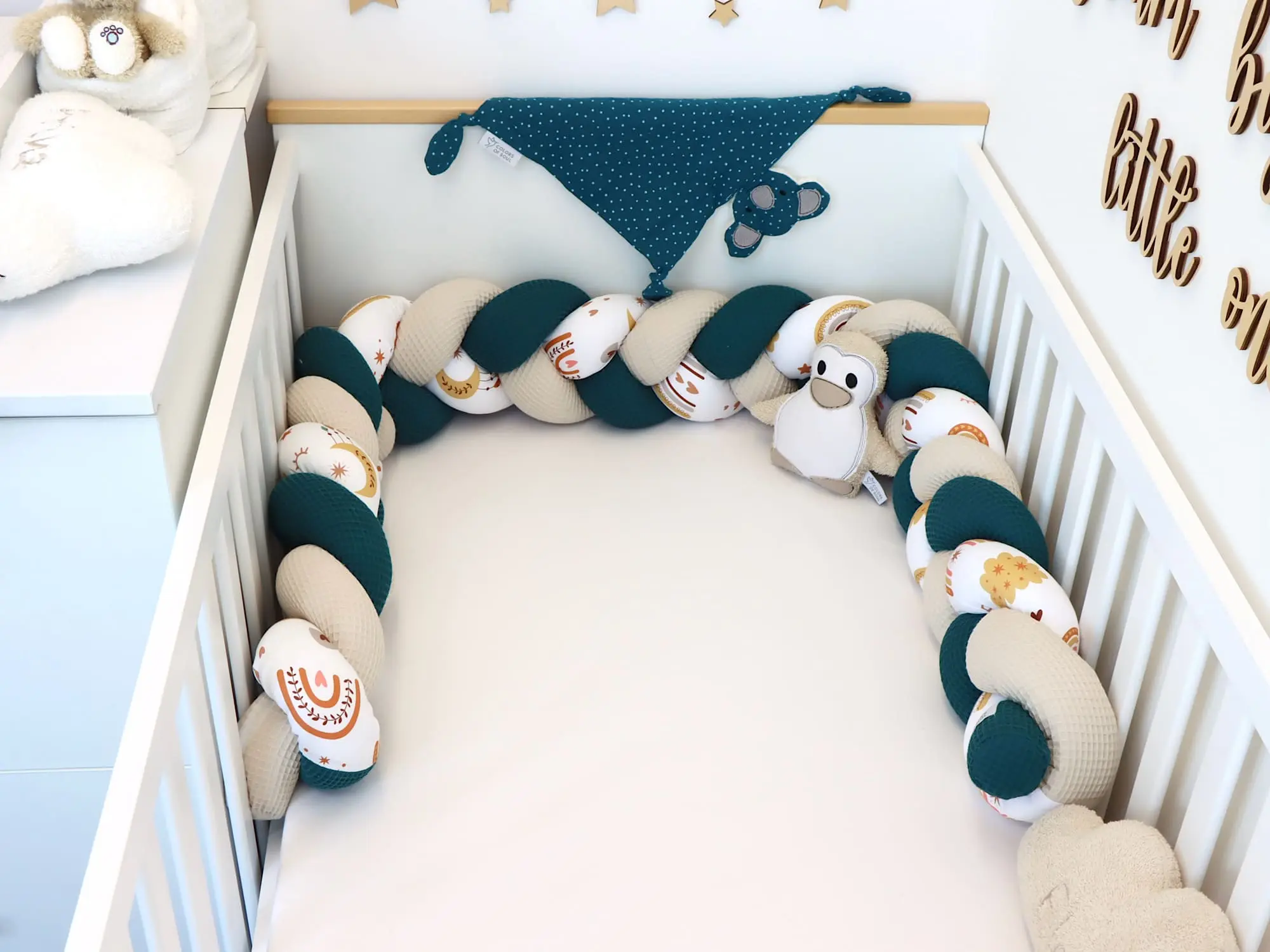 Bettschlange geflochten in Petrol Natur mit Boho Regenbogen-Muster im Babybett