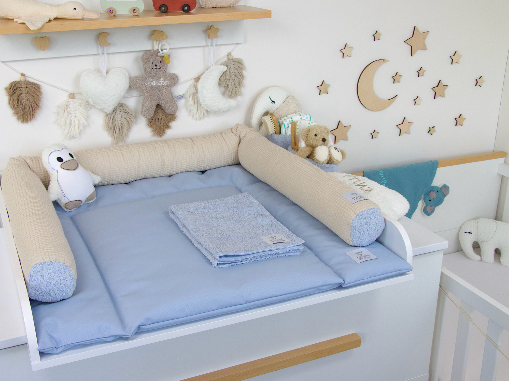 Abwaschbare Wickelauflage in Hellblau mit beiger Bettschlange – liebevoll eingerichteter Wickelplatz im Babyzimmer