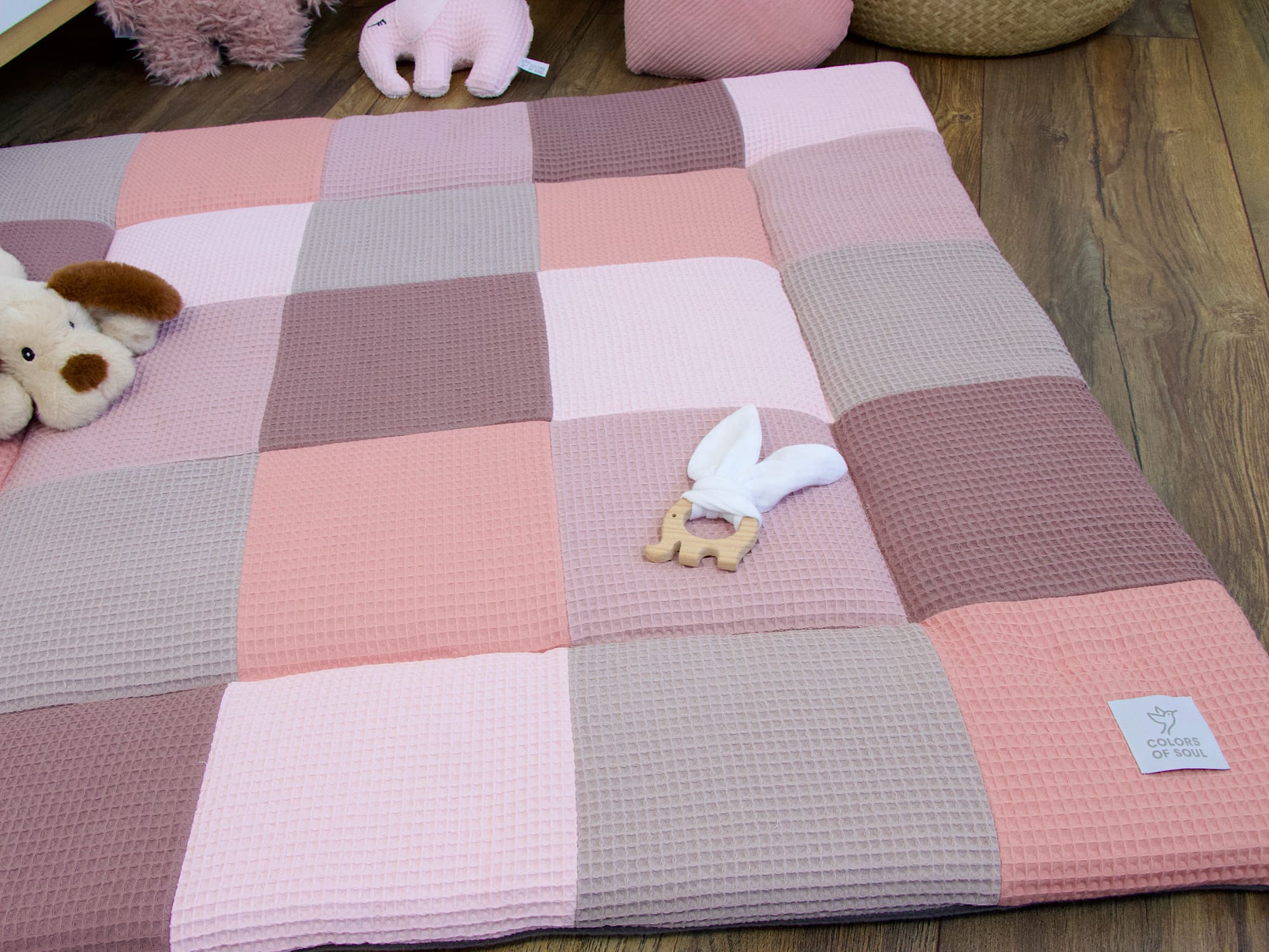 Patchwork Babykrabbeldecke aus Waffelpique in zarten Rosatönen auf Holzboden – handgefertigte Krabbeldecke