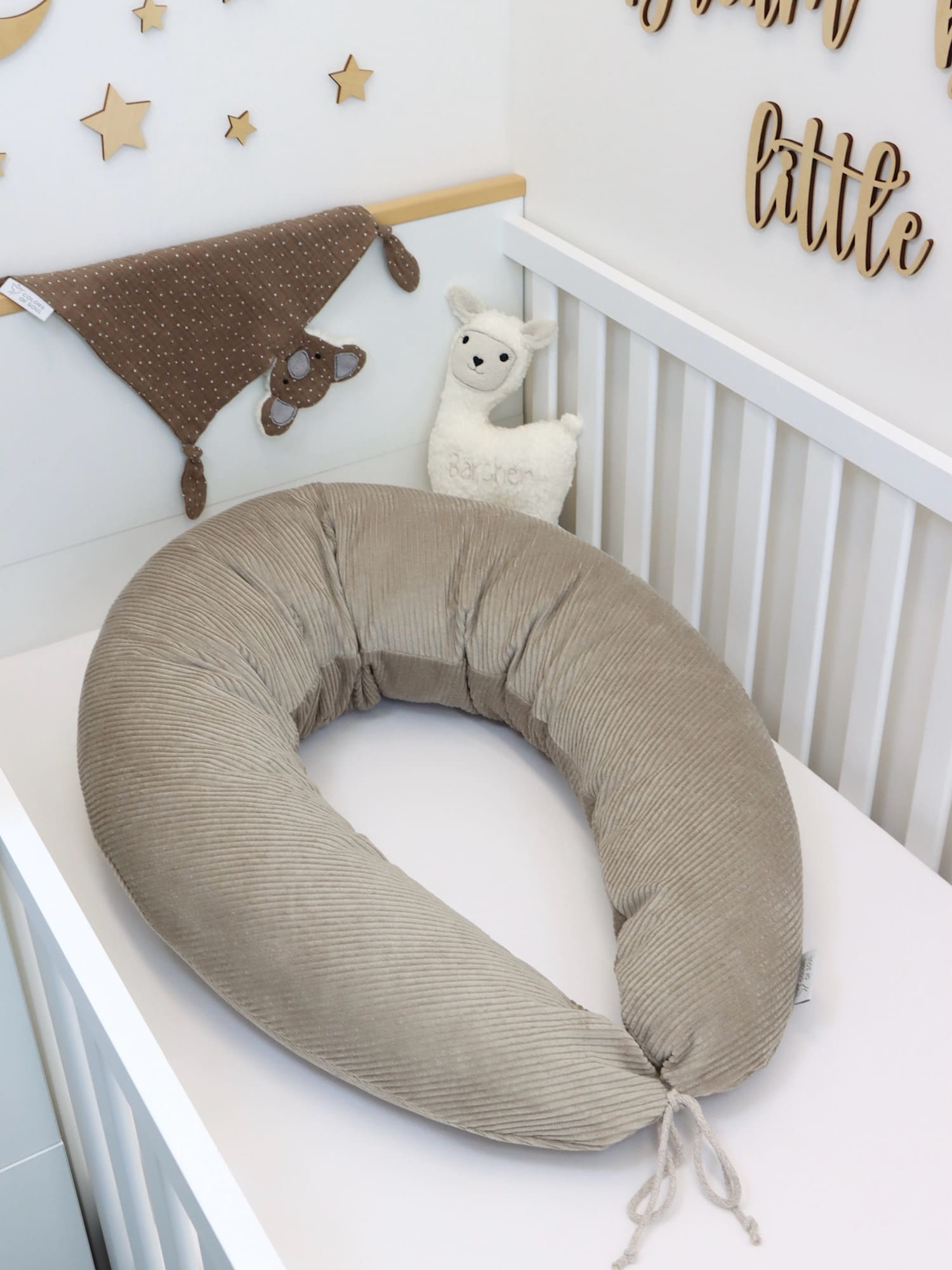 Stillkissen XXL aus beigem Cord in Babybett – handgemachtes Schwangerschaftskissen für bequemes Stillen und Seitenschlafen