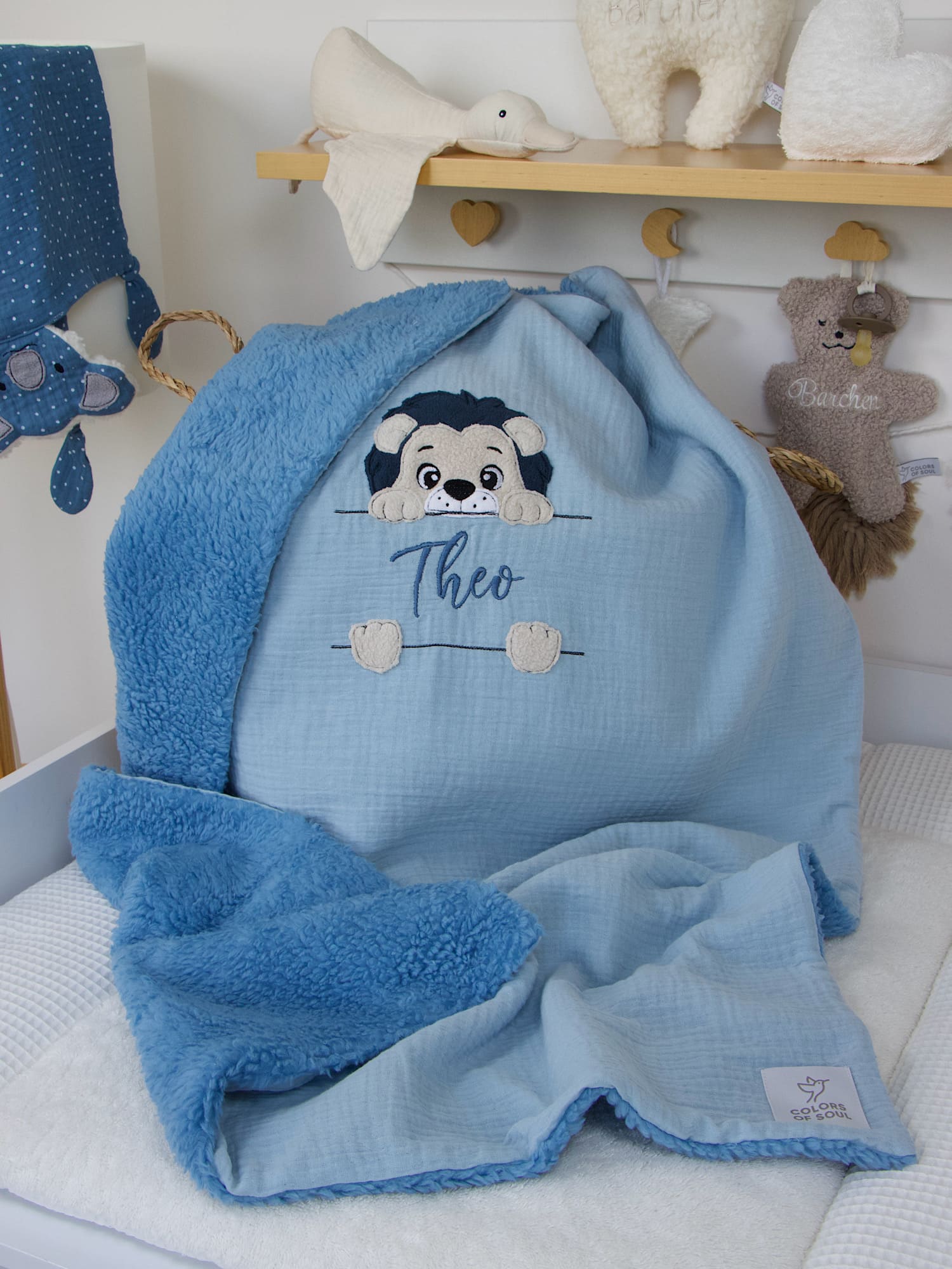 Löwe-Applikation mit Pfötchen und gesticktem Namen auf hellblauer Babydecke