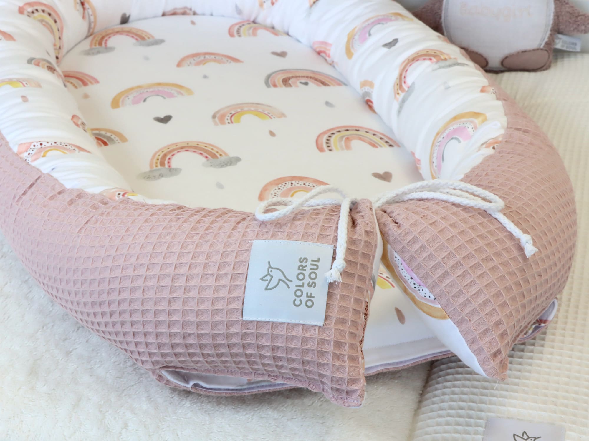 Babynestchen Regenbogen mit rundem, gepolstertem Rand aus Baumwollsatin und Waffelpique.