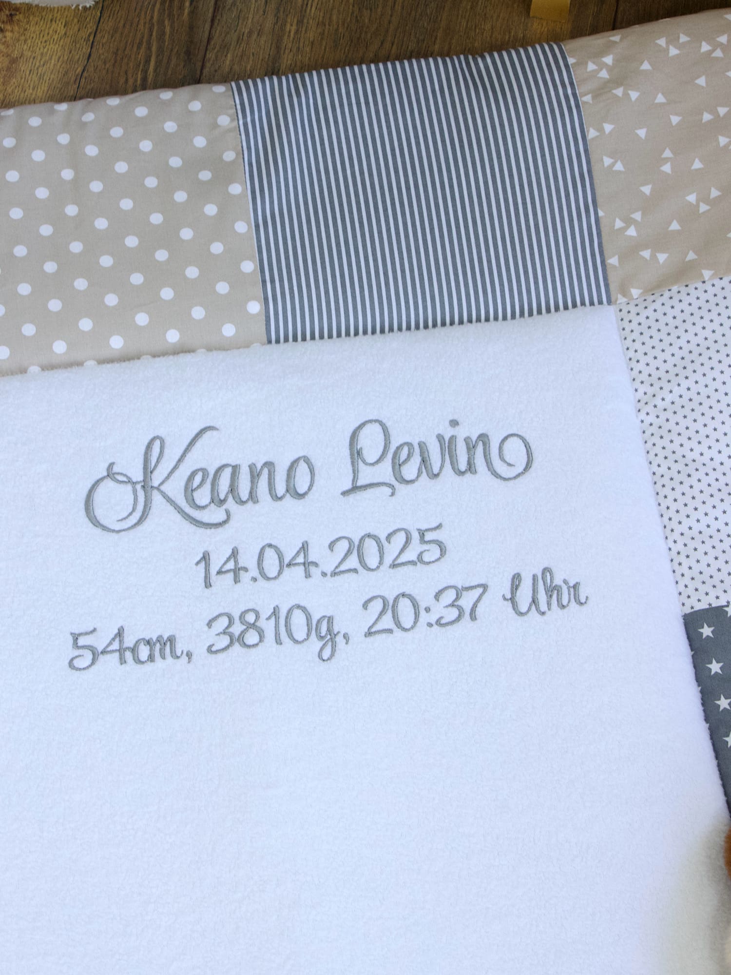 Detailansicht: Name und Geburtsdatum auf der personalisierten Krabbeldecke eingestickt