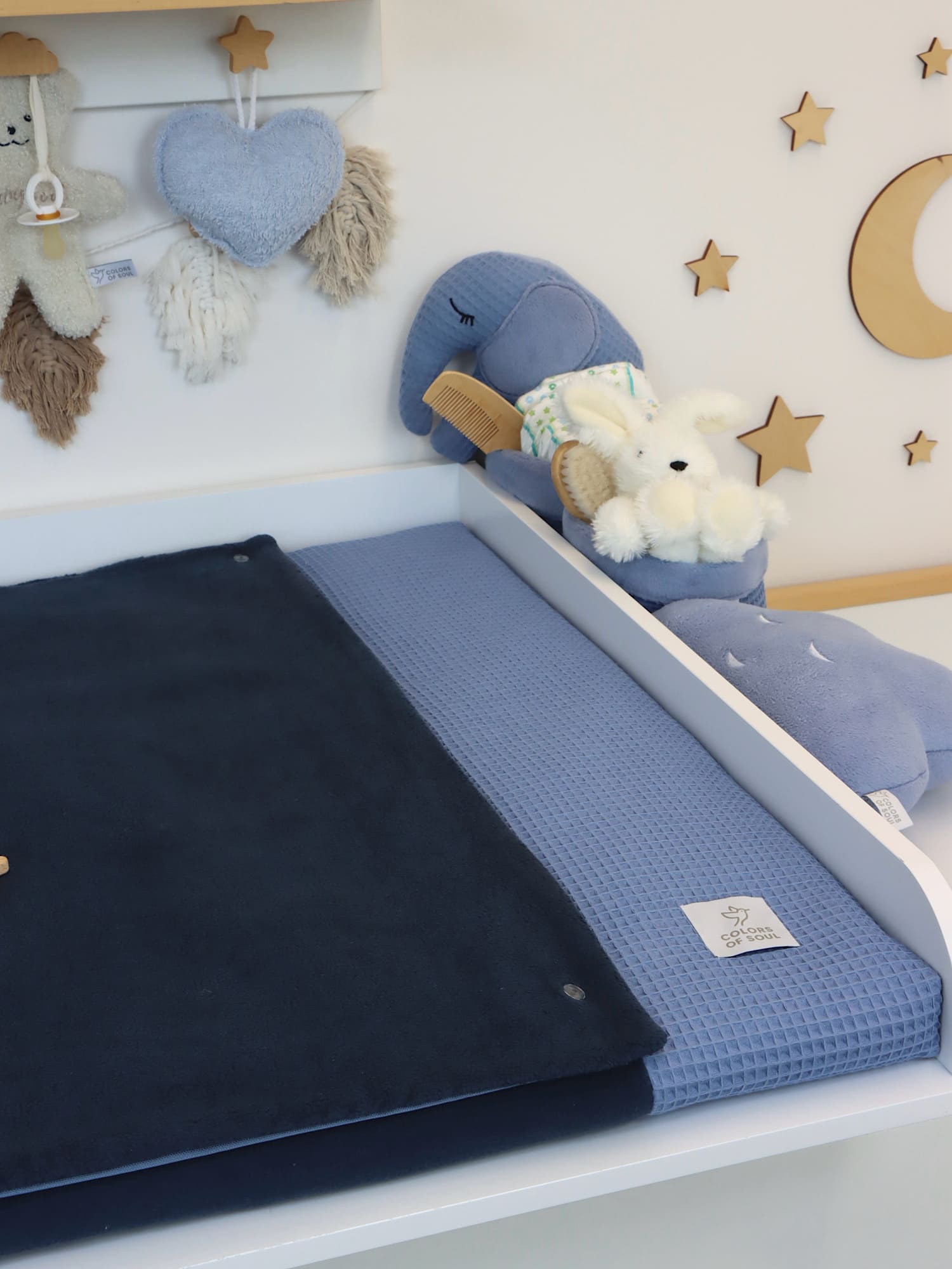 Wickelauflage in Hell- und Dunkelblau aus Waffelpique und Baumwollfleece, auf weißem Wickeltisch im Babyzimmer.