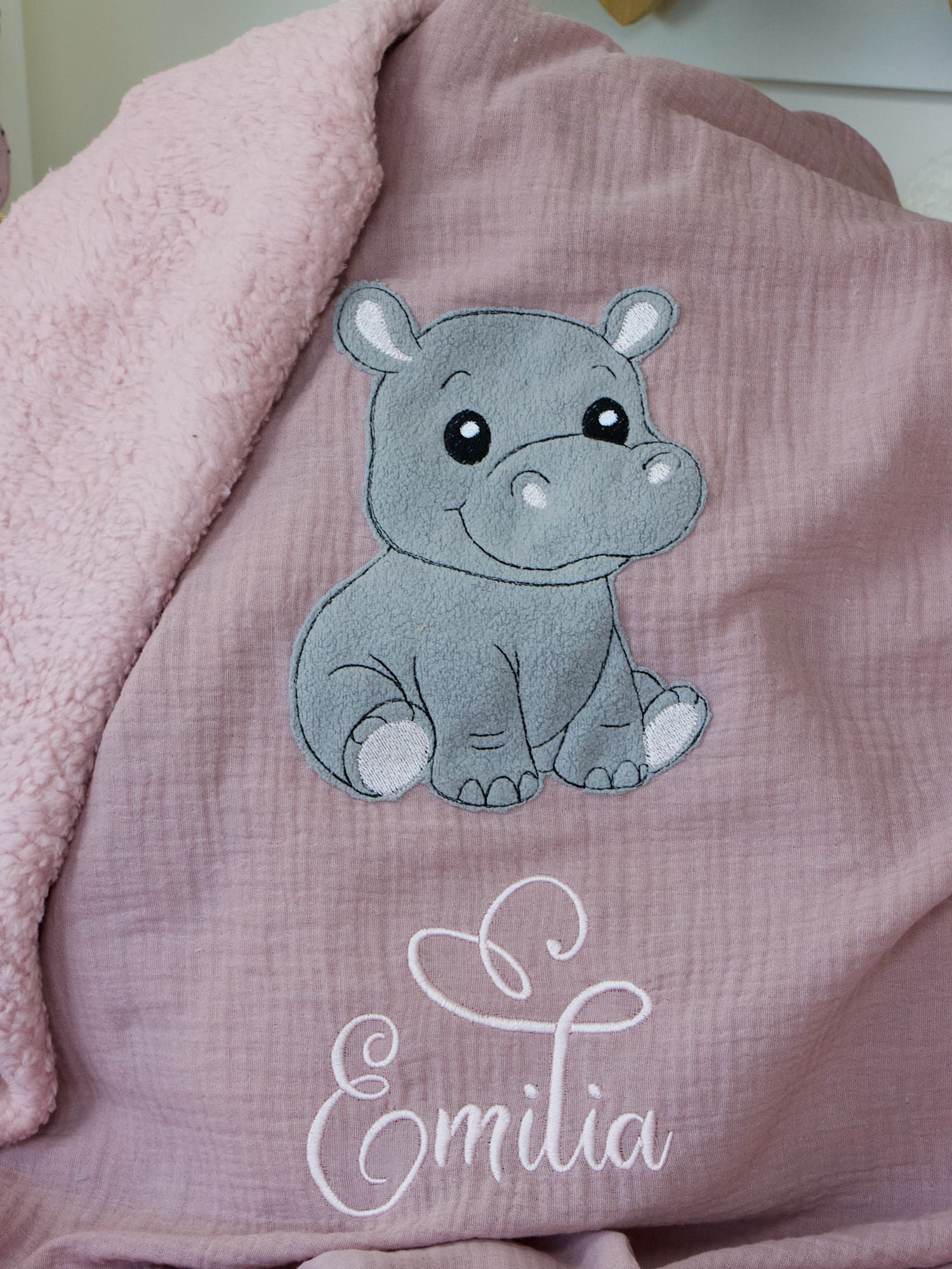 Nahaufnahme des grauen Nilpferd-Motivs auf der personalisierten Babydecke in Puderrosa mit Teddyplüsch-Futter in Altrosa