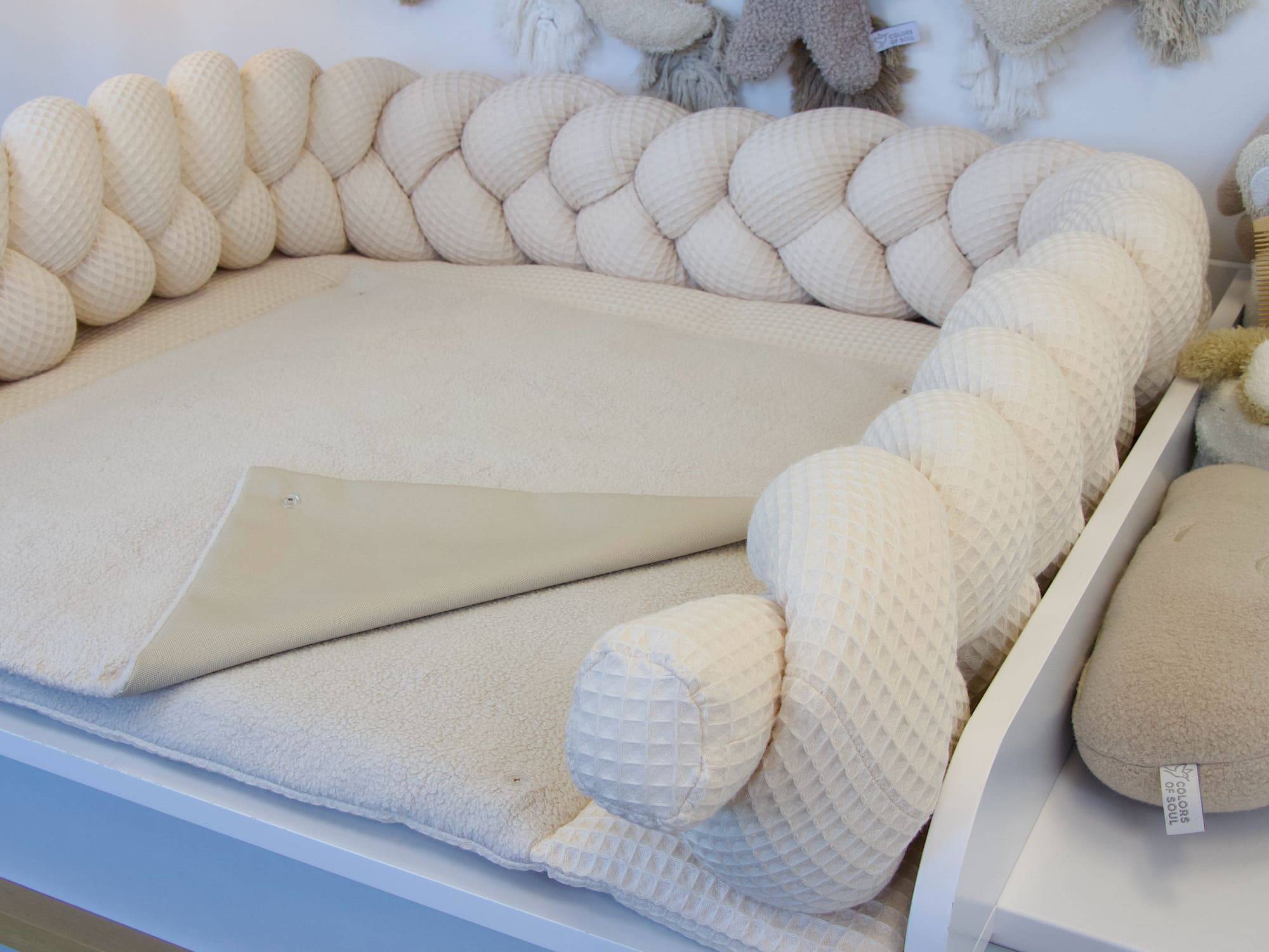 Babyzimmer mit Wickelauflage und geflochtener Bettschlange in hellbeige