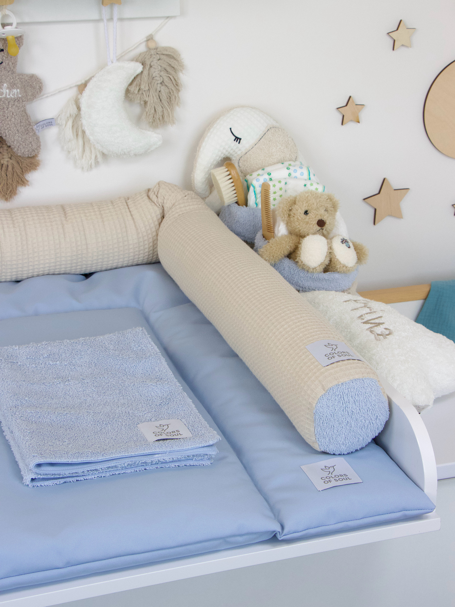 Zarte Wickelauflage in Hellblau auf Wickelkommode – sanftes Farbkonzept in Beige und Blau mit Dekoration aus Naturmaterialien