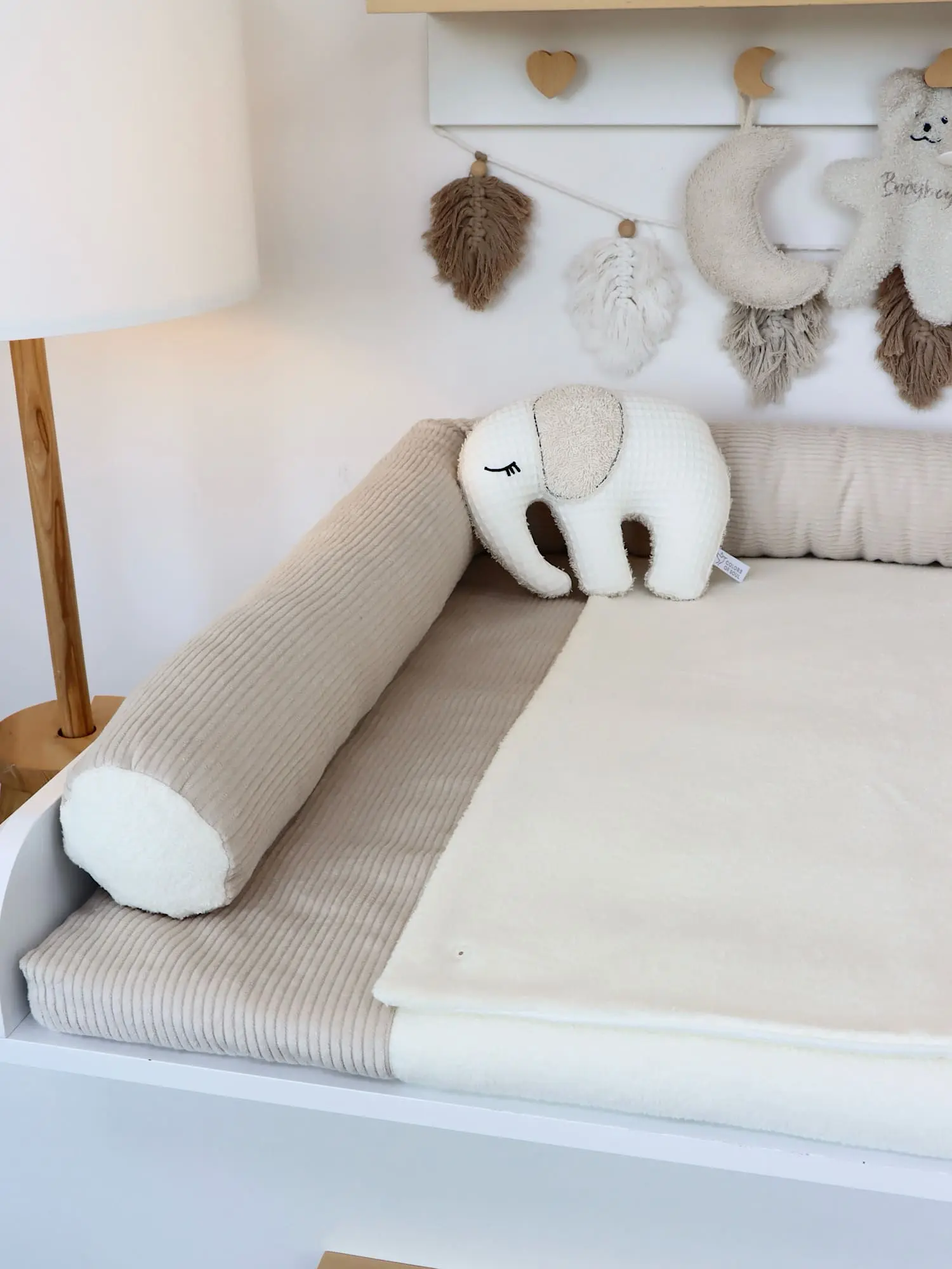 Klassische Bettschlange aus Cord Light Sand auf weißer Wickelkommode