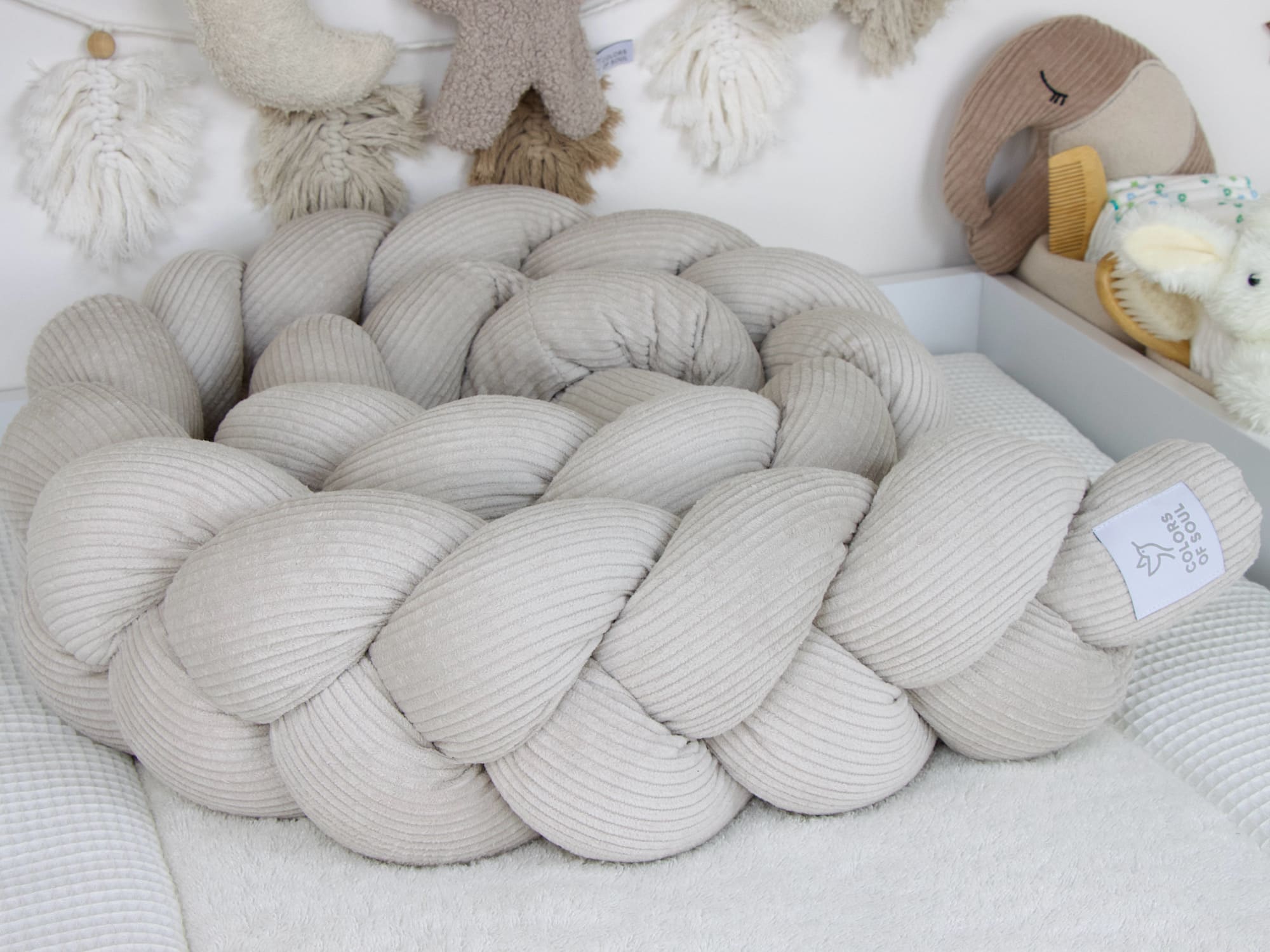 Geflochtene Bettschlange aus Cord in Hellbeige im Babybett – sanfter Kantenschutz