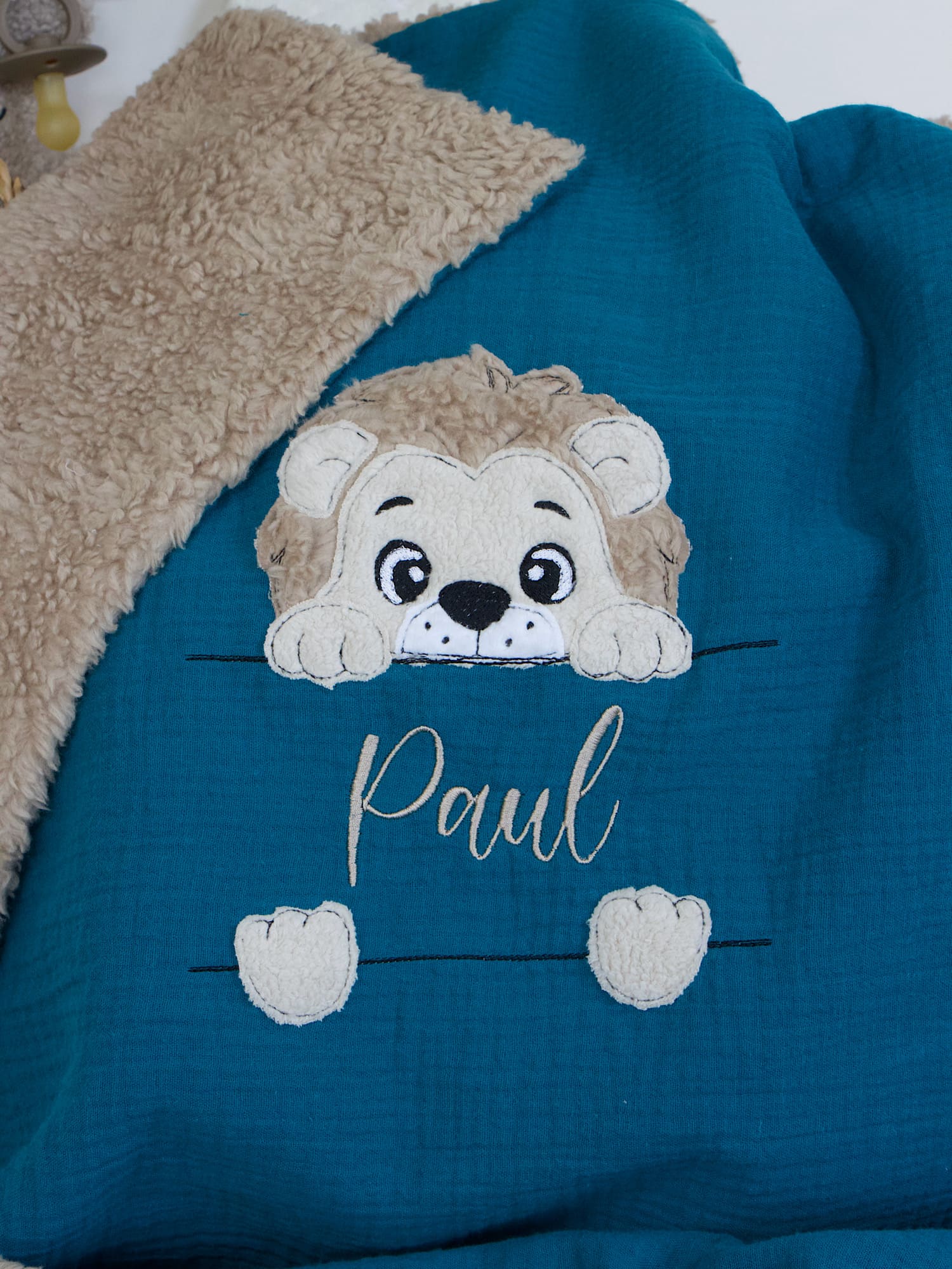 Personalisierte Babydecke in Petrol mit Löwen-Motiv – Kuscheldecke aus Musselin und Teddyplüsch in Sand, bestickt mit Namen.