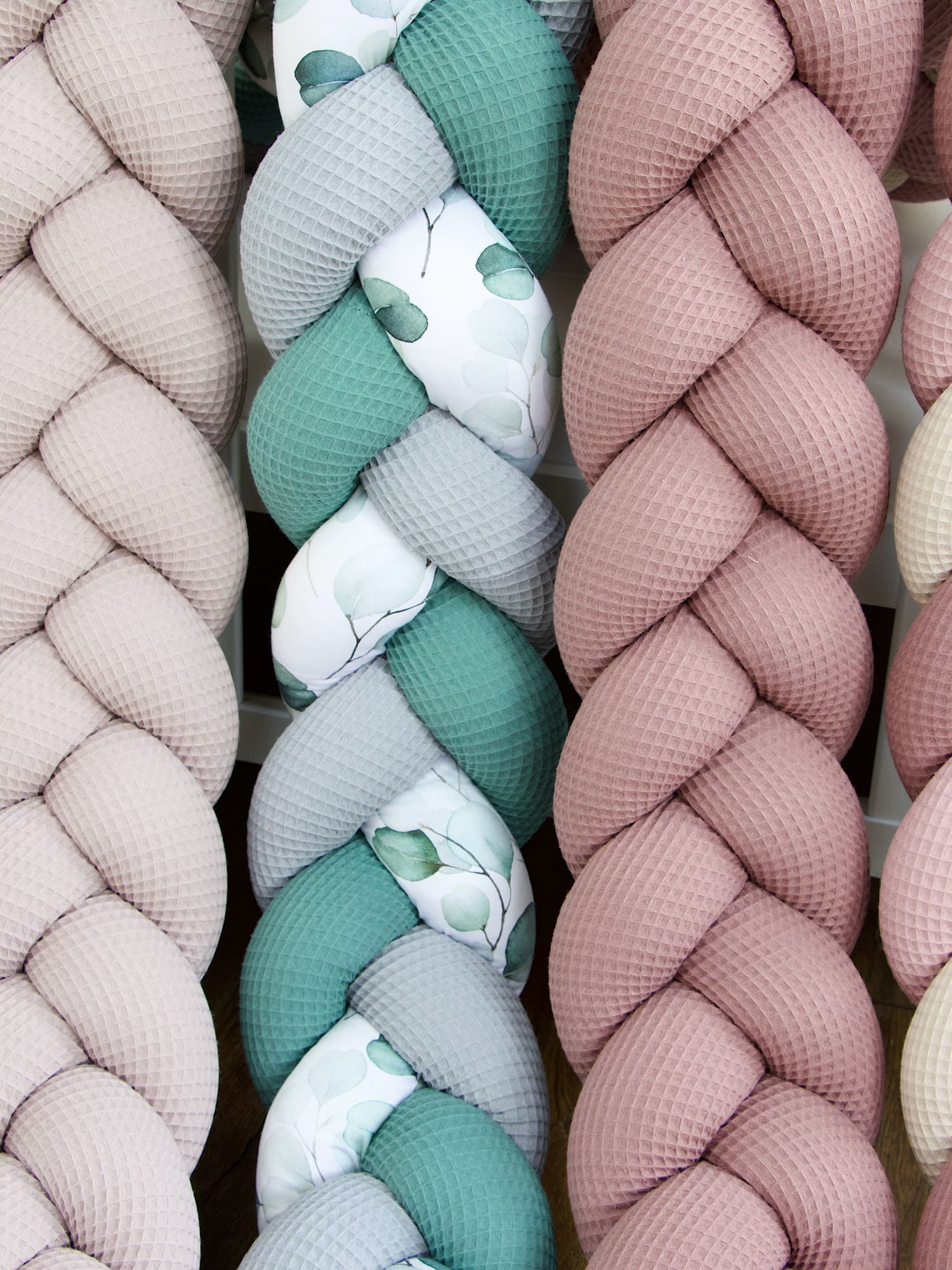 Geflochtene Bettschlangen in Altgrün-Grau und Rosa-Tönen – handgefertigt aus Waffelpique mit Eukalyptus-Aquarell