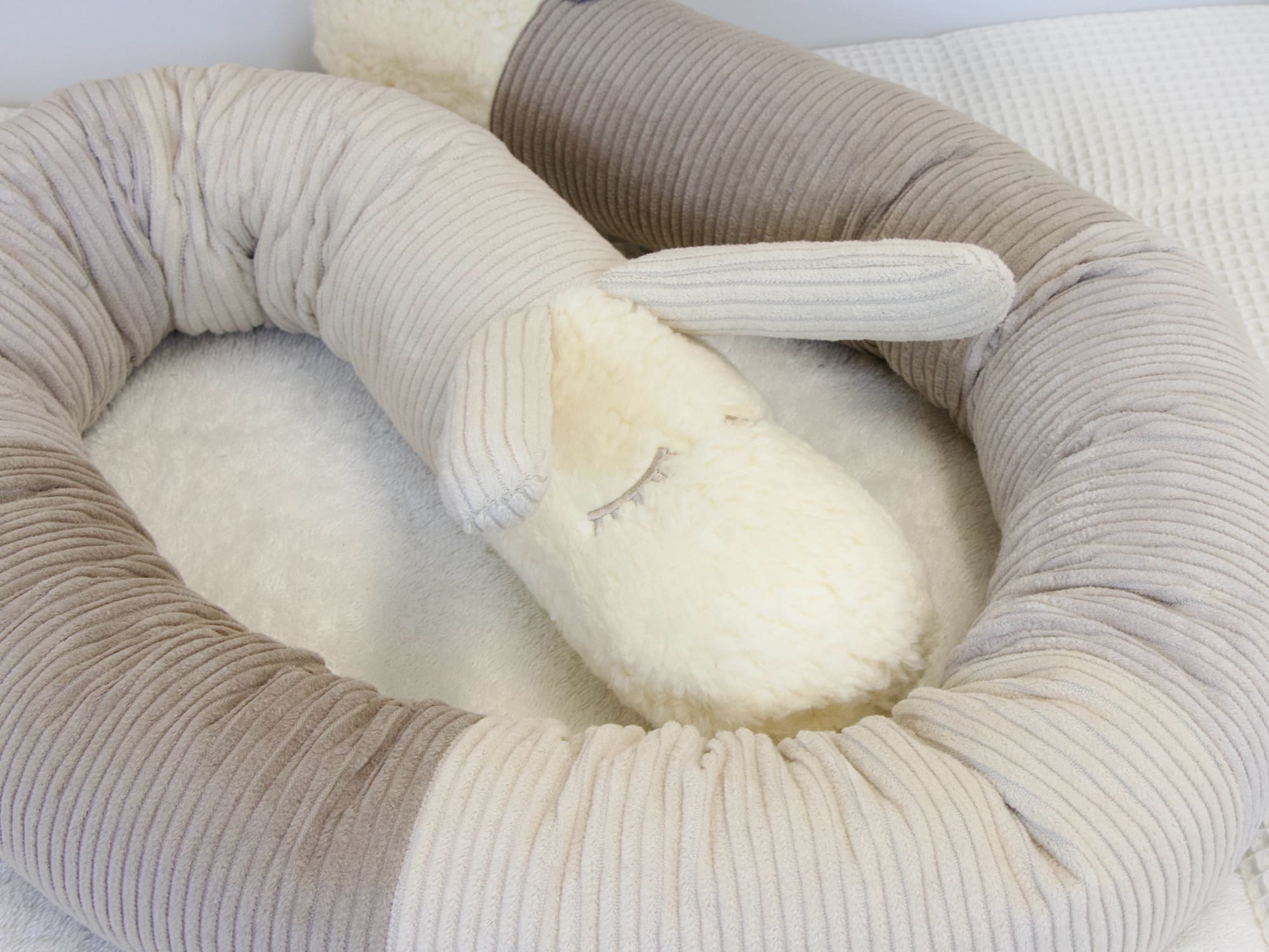 Gerollte Bettschnecke aus Cord in Sand und Hellbeige auf Matratze