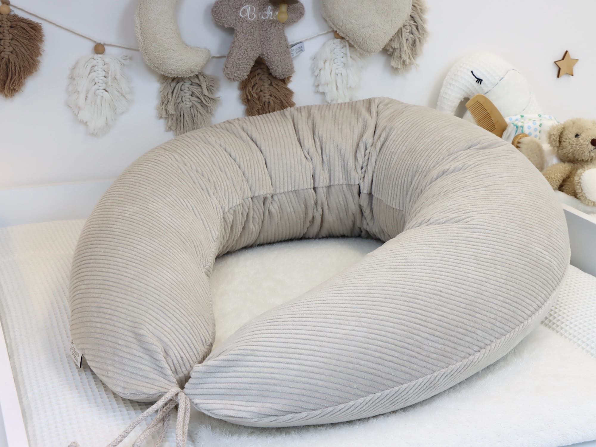 Stillkissen XXL Cord Hellbeige – ergonomische Form im Babybett arrangiert