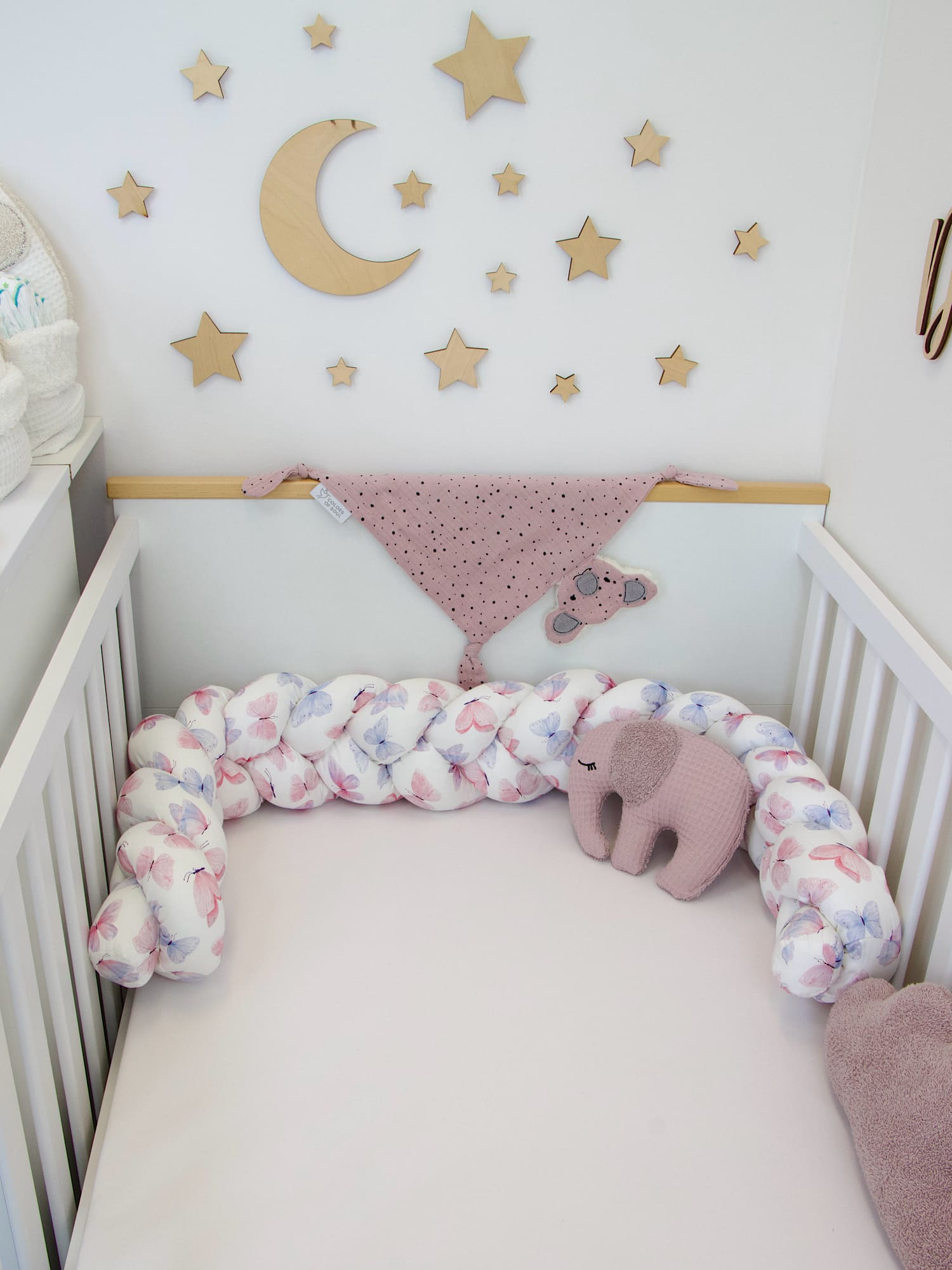 Geflochtene Bettschlange Schmetterlinge Aquarell mit rosa Elefanten-Kissen im Babyzimmer