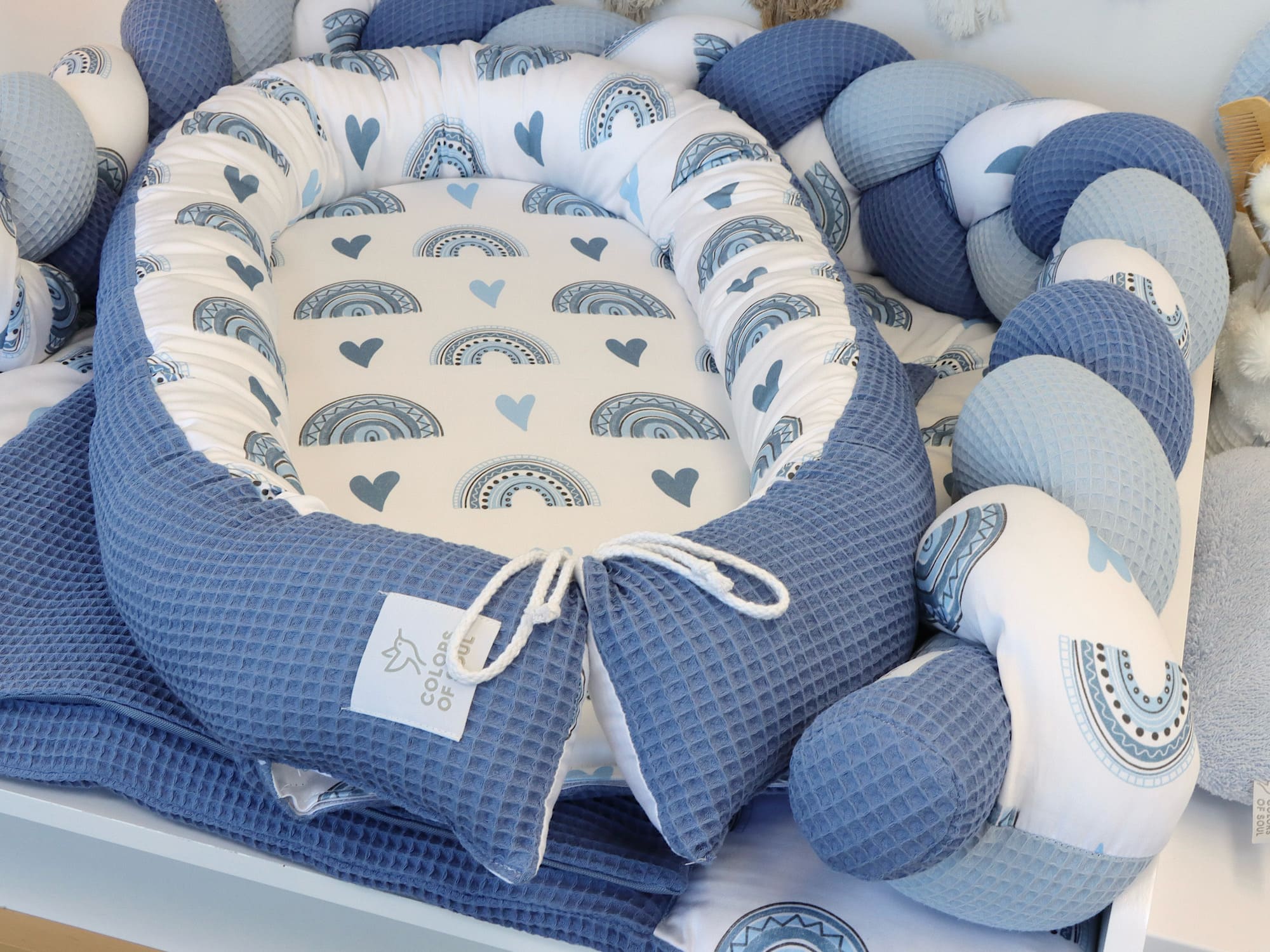 Wickelauflage, geflochtene Umrandung, Babynest - Regenbogen und Herzen blau / Waffelpique blau
