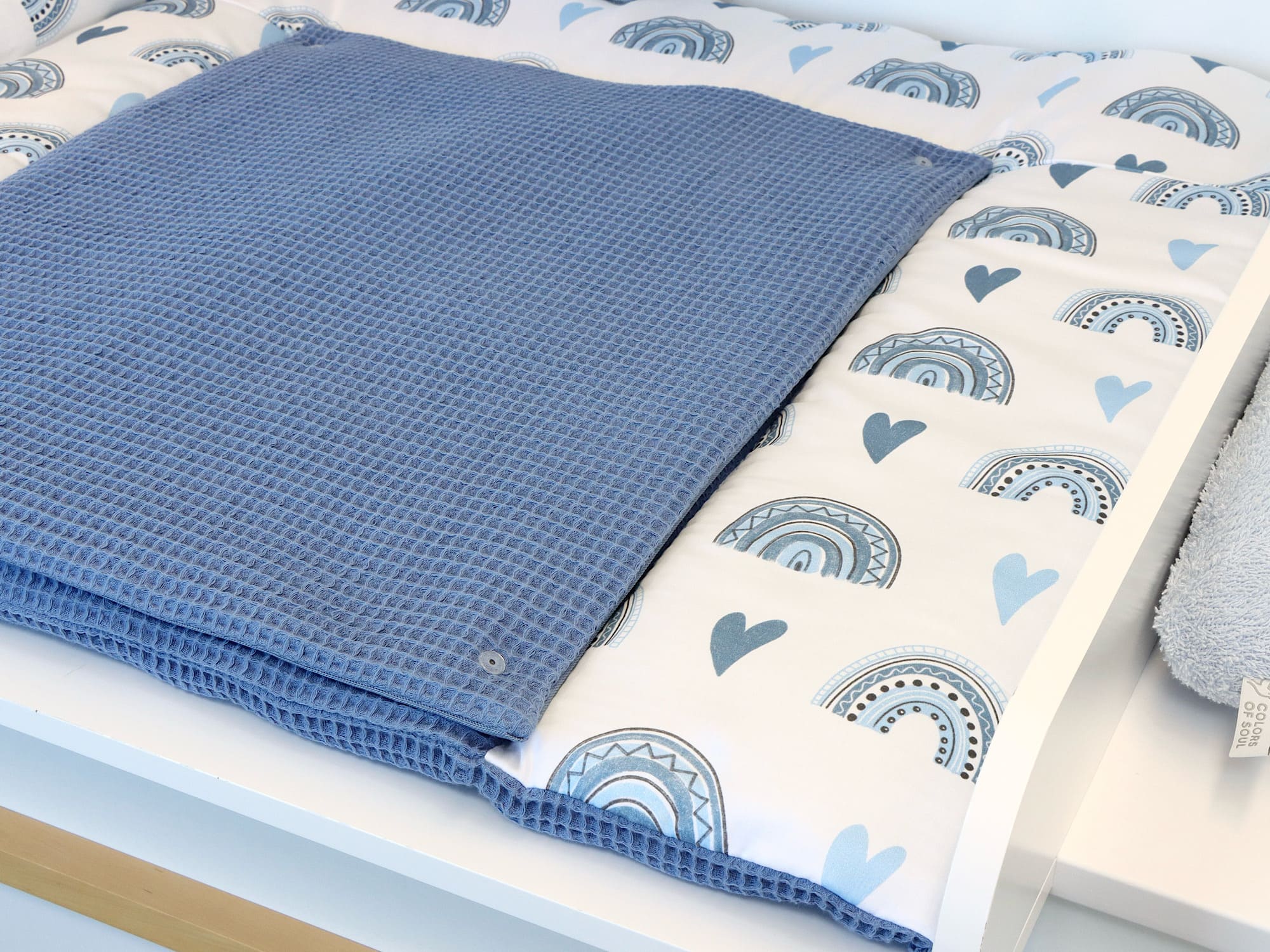 Wickelauflage, geflochtene Umrandung, Babynest - Regenbogen und Herzen blau / Waffelpique blau