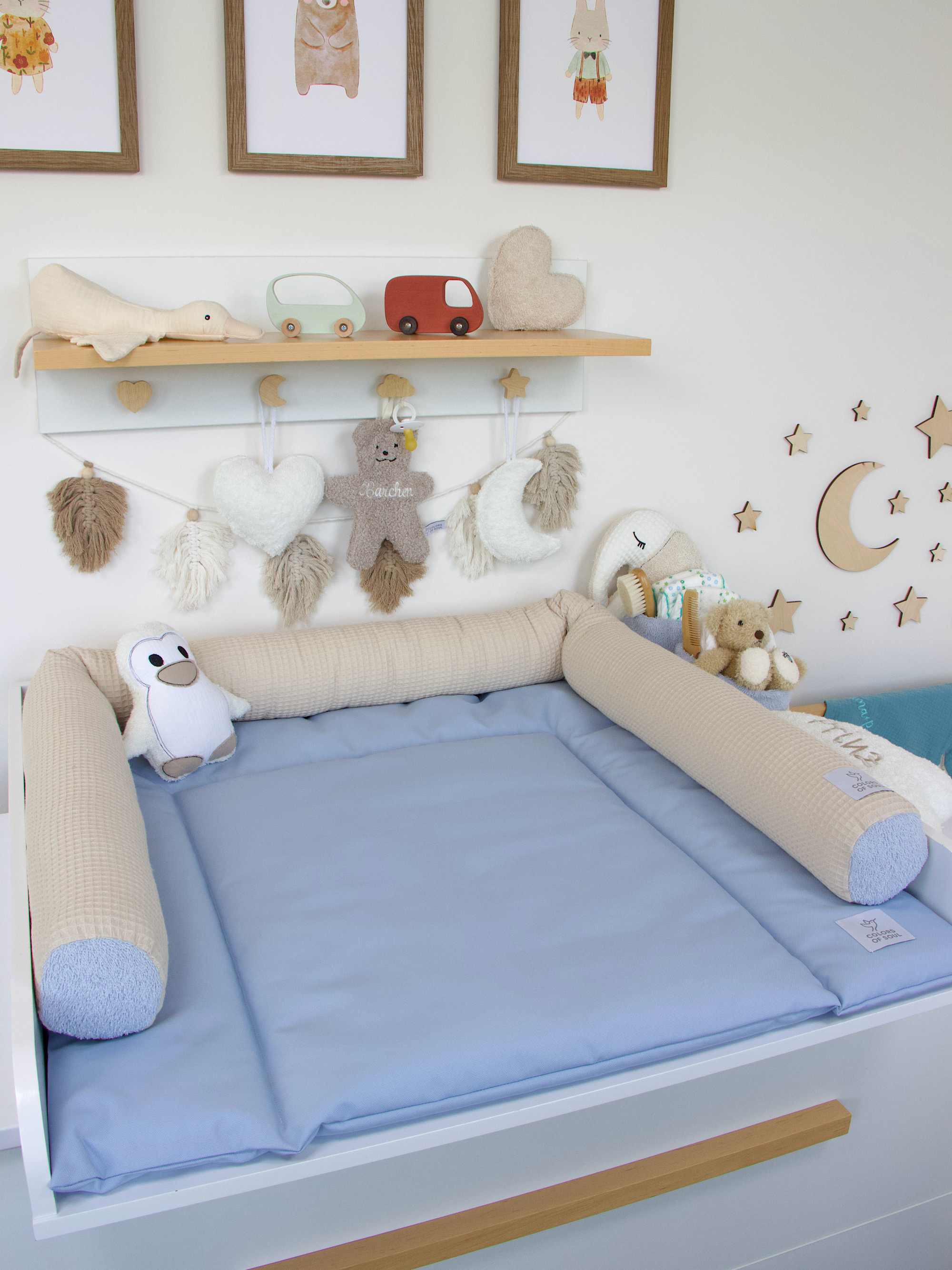 Baby Wickelauflage in Hellblau – harmonisch kombiniert mit Kuscheltieren, Sternen-Deko und Mondmotiv an der Wand