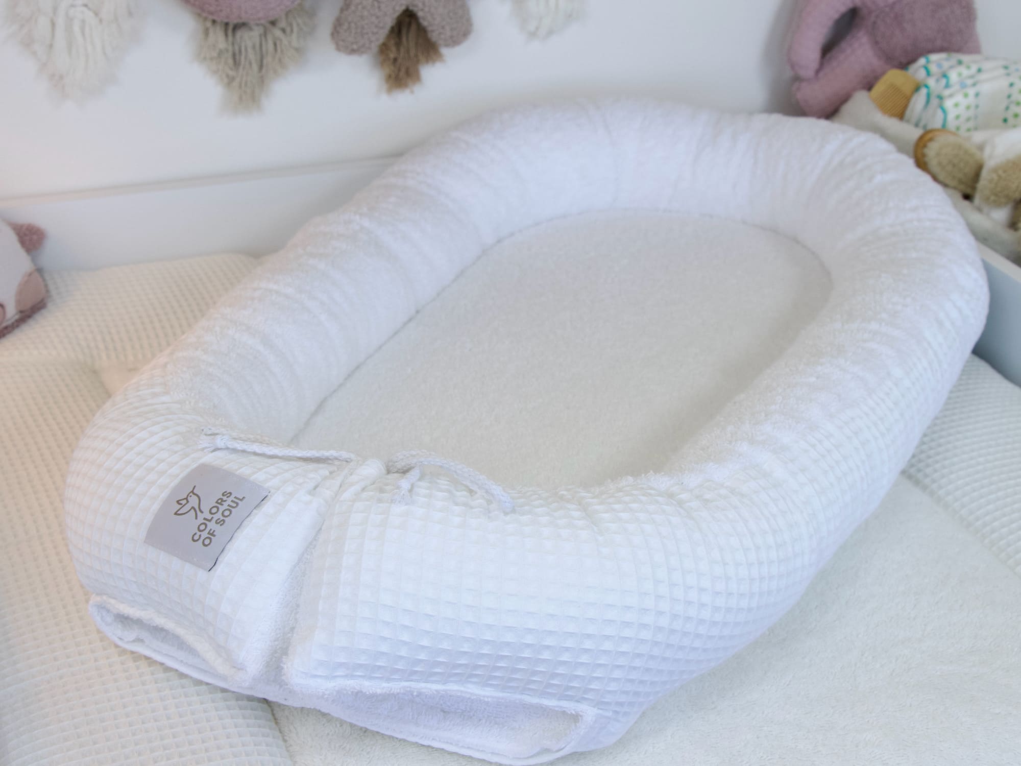 Weißes Babynest aus Frottee und Waffelpique – kuscheliger Rückzugsort für Neugeborene