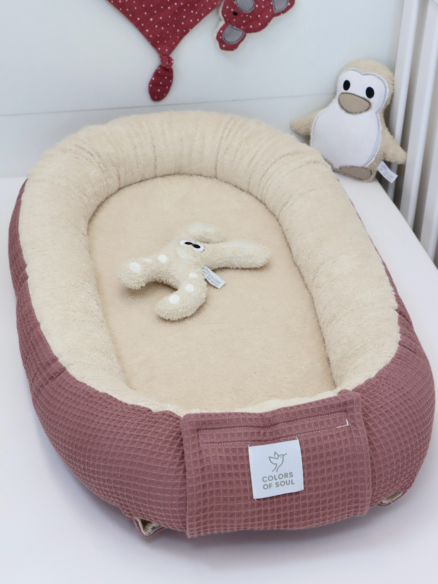 Natürliches Babynest in warmen Beige- und Malvetönen