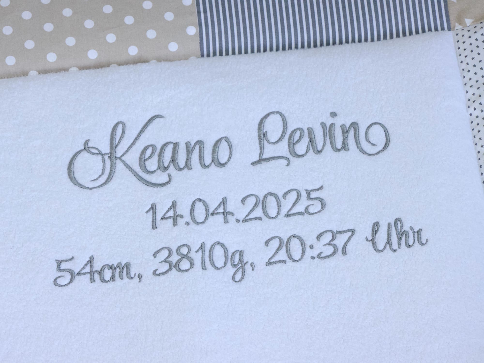 Detailansicht: Name und Geburtsdatum auf der personalisierten Krabbeldecke eingestickt