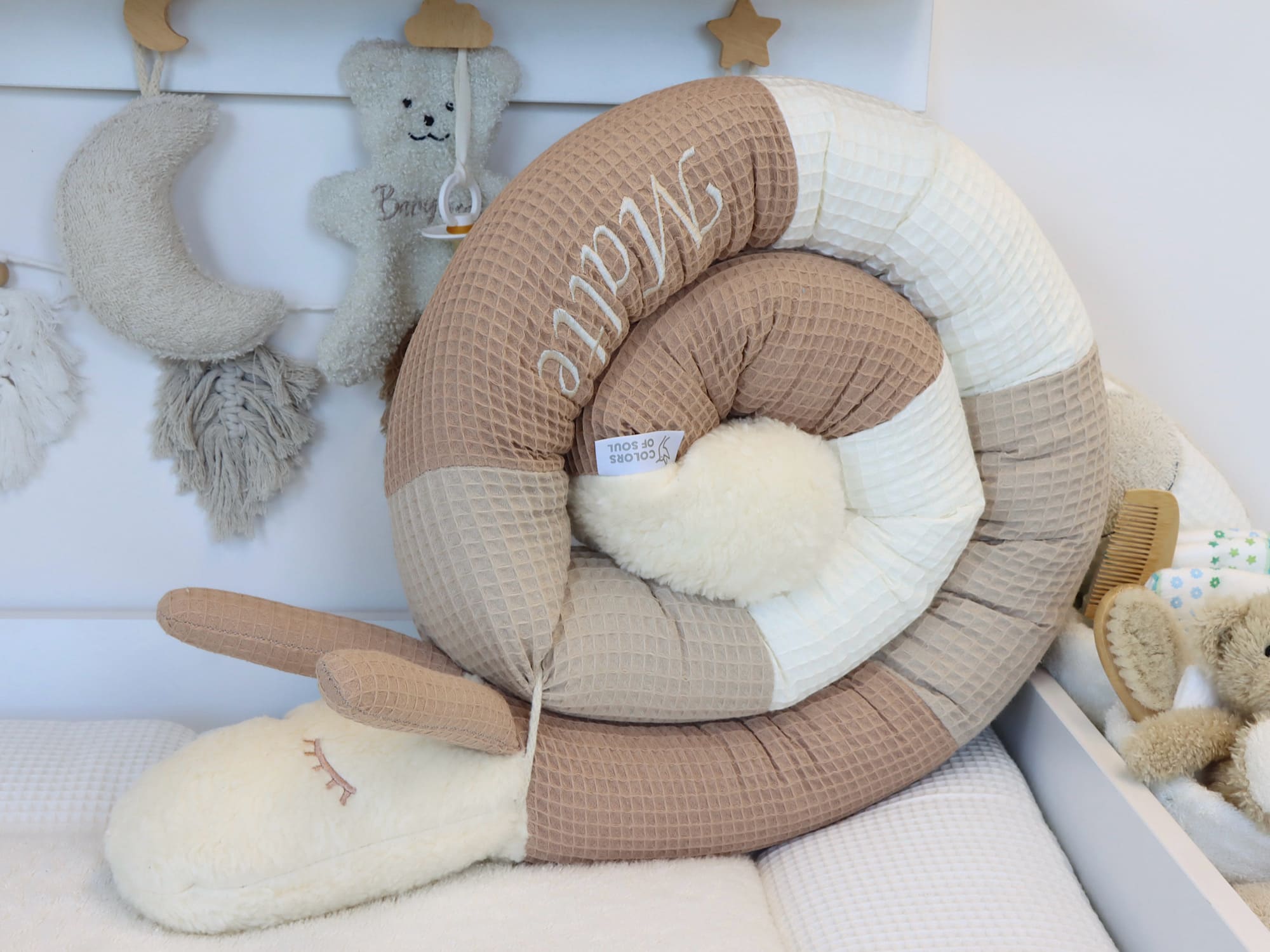 Handgefertigte Puckschnecke aus Waffelpique in Camel, Beige und Creme – liebevoll genäht und personalisiert mit Namen, ideal als Bettschlange fürs Babybett.