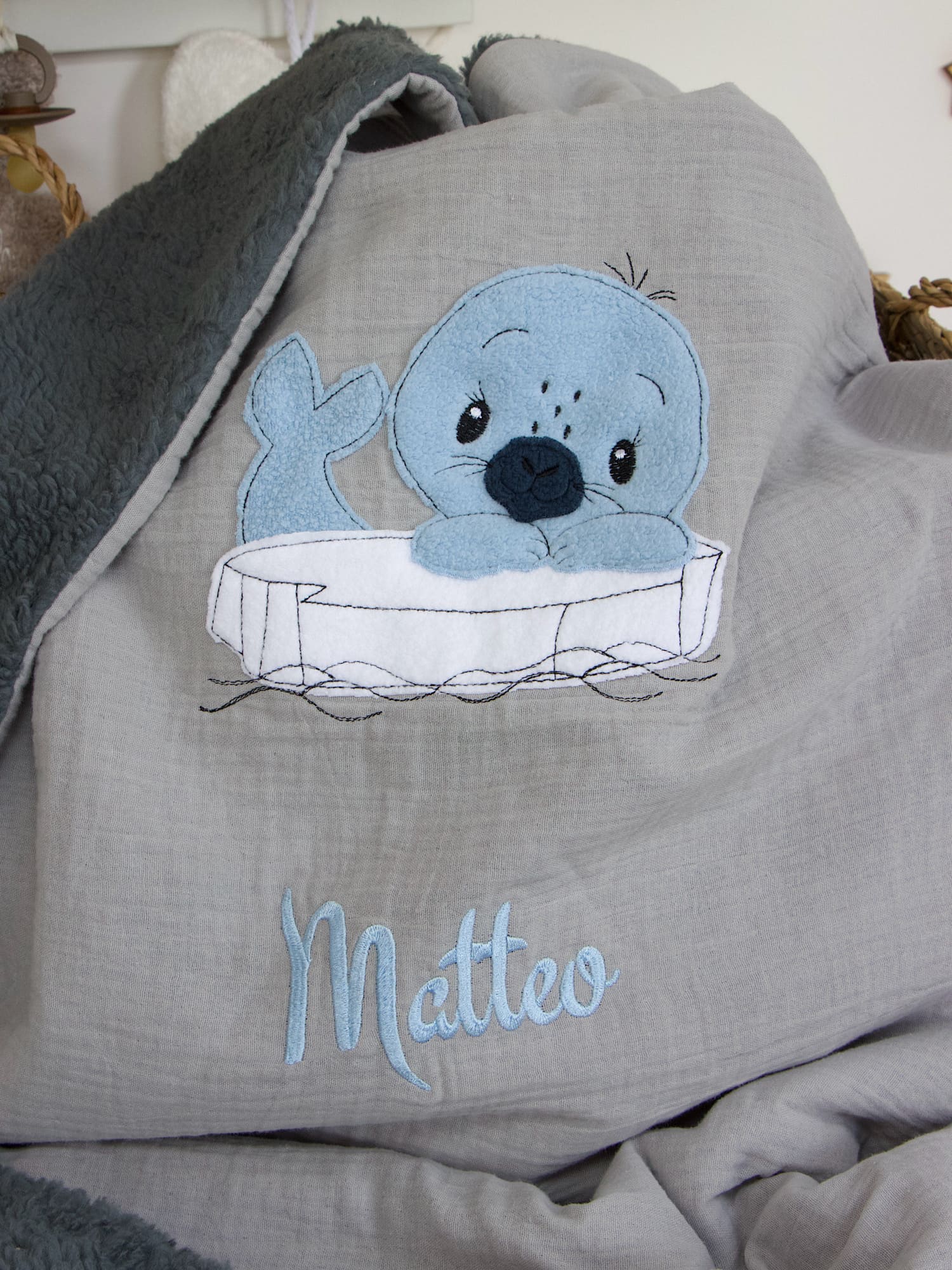 Personalisierte Babydecke in Hellgrau mit dunkelgrauem Teddyplüsch, bestickt mit Seehund und Name „Matteo“