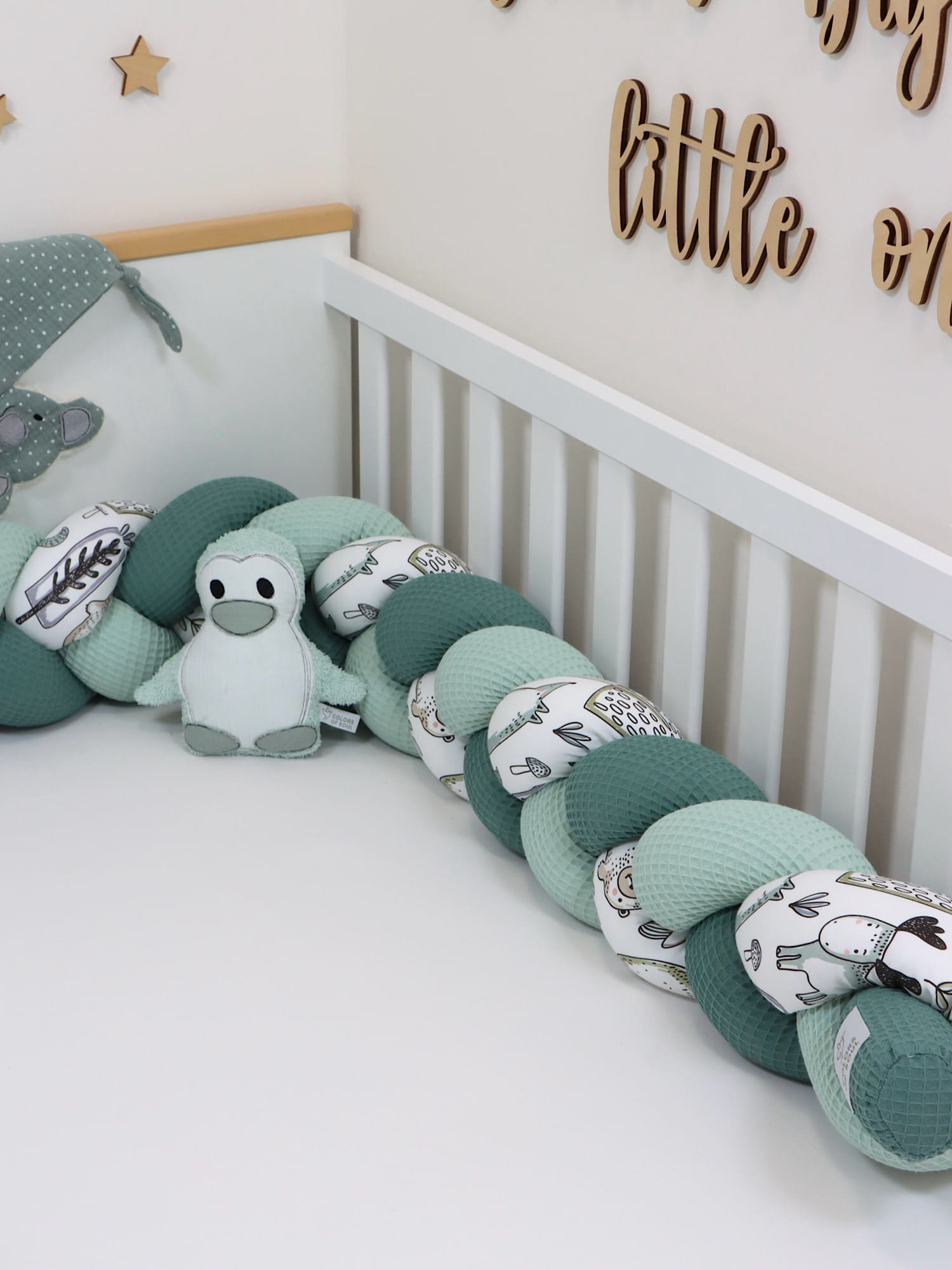 Geflochtene Bettschlange im Babybett – Farben Hellmint und Altgrün mit liebevollem Waldfreunde-Druck