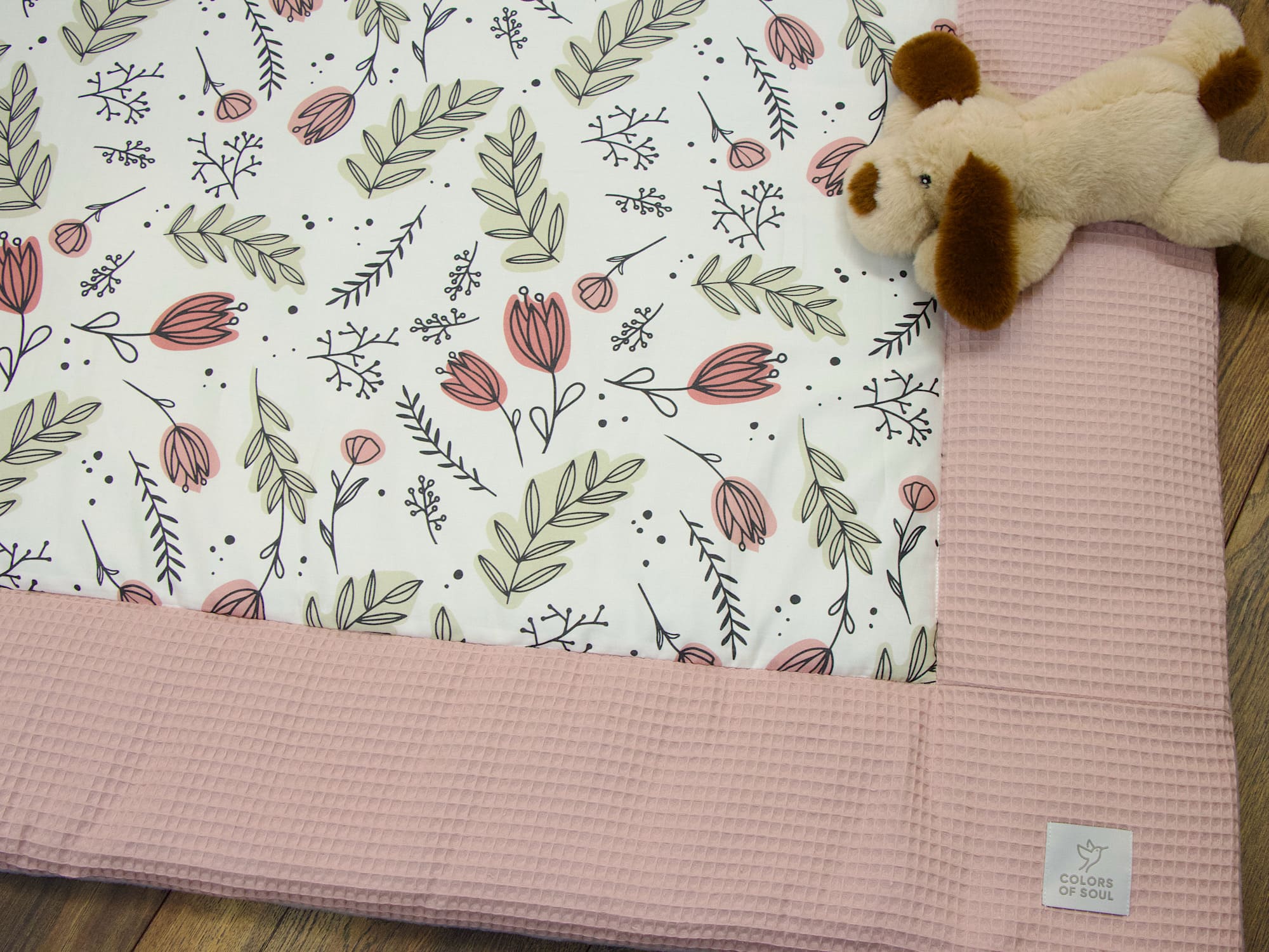 Detailaufnahme der Krabbeldecke mit abstraktem Tulpenmuster und altrosa Rand