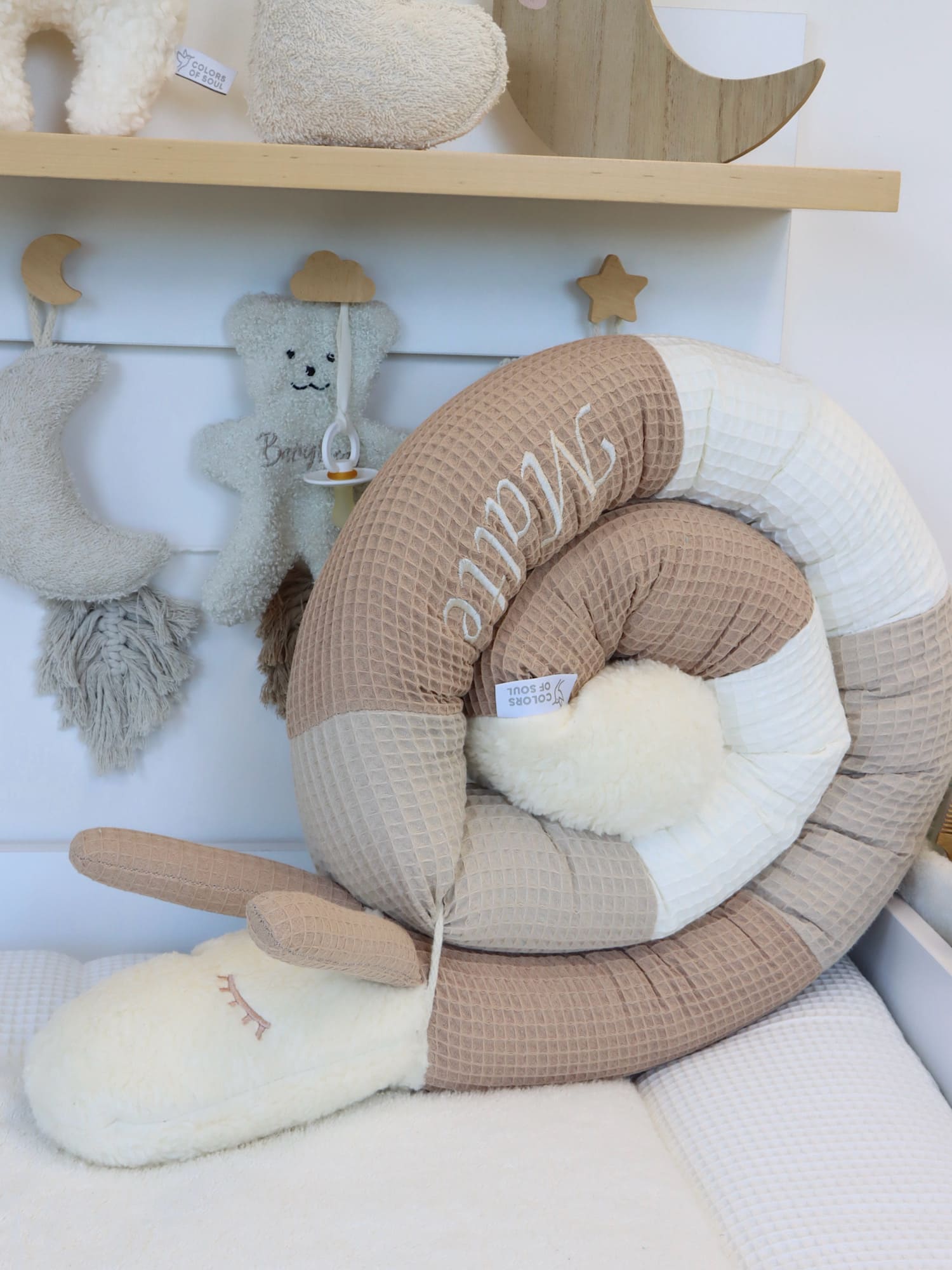 Bettschnecke aus Waffelpique in warmen Naturtönen Camel, Beige und Creme – handgefertigte Puckschnecke mit Namensstickerei im Babyzimmer.