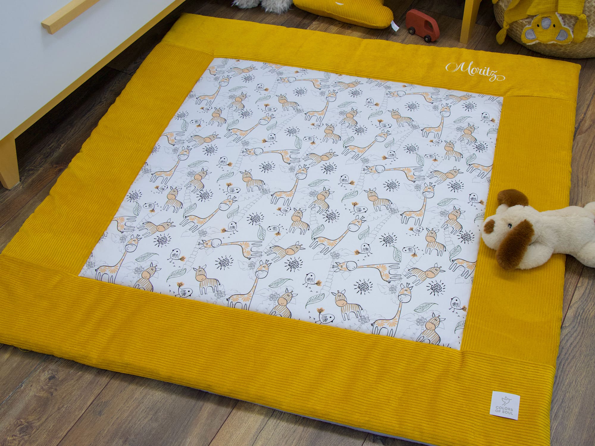 Detailaufnahme der Krabbeldecke mit Safari-Motiv und gelbem Cordrahmen
