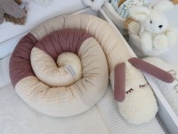 Puckschnecke aus Waffelpique in hellbeige, natur und alter Malve eingerollt im Babybett