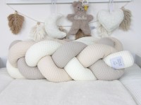 Geflochtene Bettschlange aus Waffelpique in Creme, Beige und Hellbeige – handgefertigt und dekorativ im Babyzimmer arrangiert.