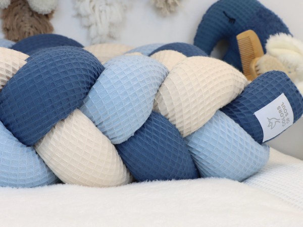 Geflochtene Bettschlange aus Waffelpique in Hellblau, Jeansblau und Hellbeige im Babybett