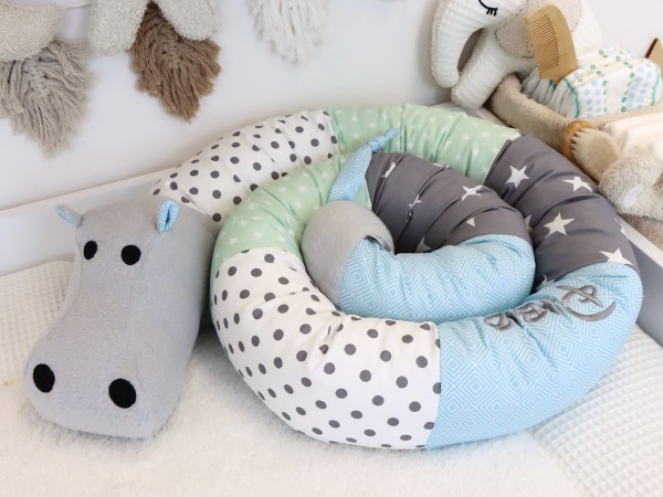 Bettschlange Nilpferd mint/grau/weiß/blau mit Punkten und Sternen – zusammengerollt im Babyzimmer