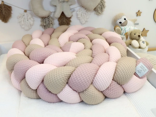 Geflochtene Bettschlange Hellrosa Altrosa Beige im weißen Babybett