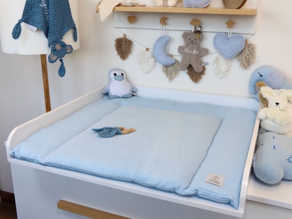 Hellblaue Wickelauflage aus Waffelpique und Fleece im Babyzimmer – weiche Auflage auf weißer Wickelkommode