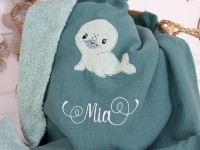 Detailaufnahme der Seehund-Applikation und Namensstickerei "Mia" auf der personalisierten Babydecke Dunkelmint